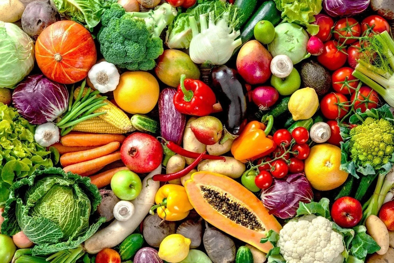 A colorful mix of fresh vegetables and fruit, including pumpkin, broccoli, peppers, tomatoes and fennel