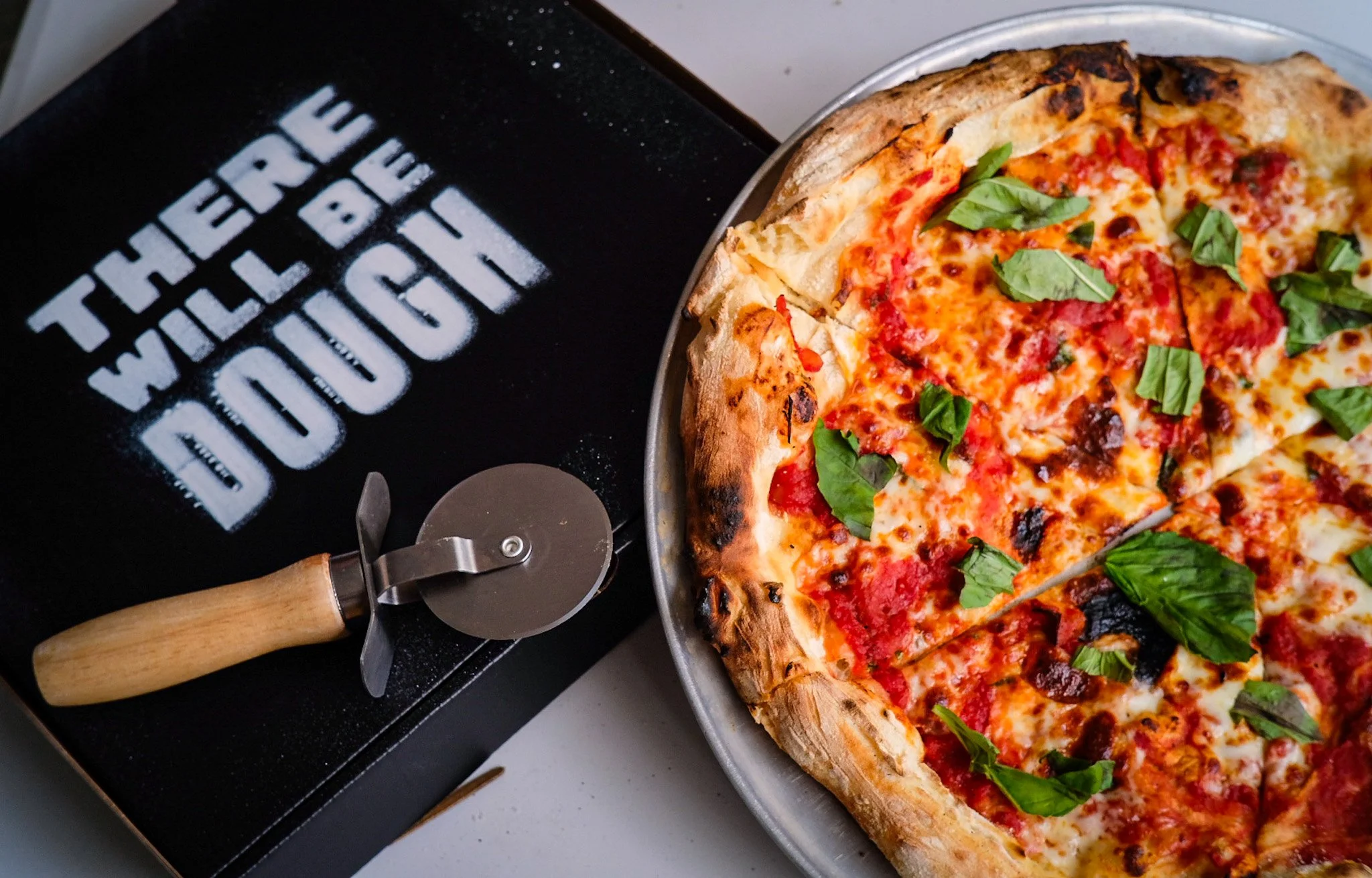 Fresh margherita pizza and cutter from There Will Be Dough, served at Red Shirt Farm's Thursday Pizza Night
