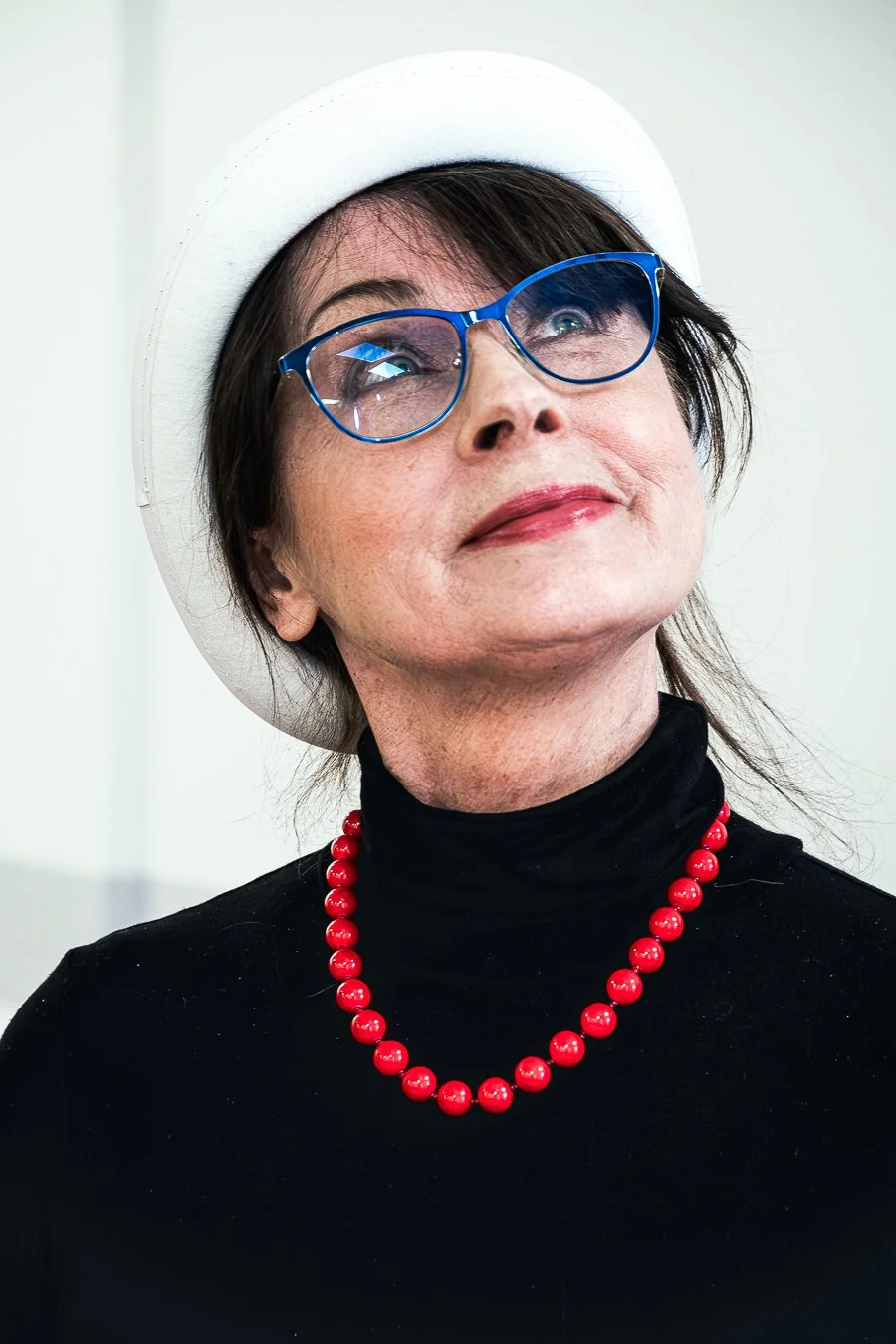 Portret stylizowany kobiety w białym kapeluszu i czerwonym naszyjniku, fotografia Konrad Uhma, Ursynów