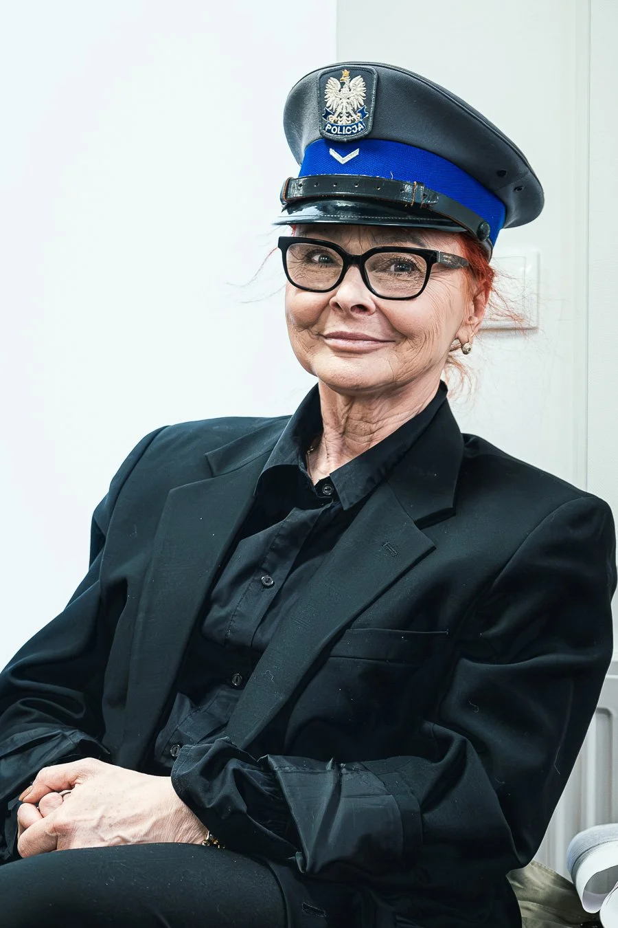 Portret stylizowany kobiety w czarnej stylizacji z czapką policyjną, fotografia Konrad Uhma, Mokotów