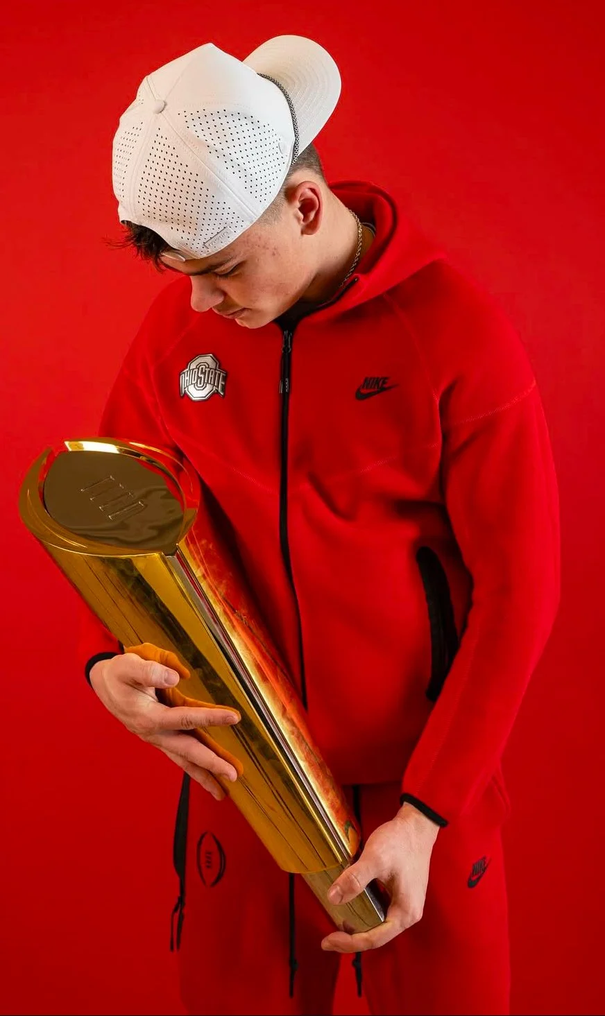 Ryan Rudzinski holding the 2024 CFP National Championship trophy after working with Dom Clegg and implementing the A1pha Execution System.