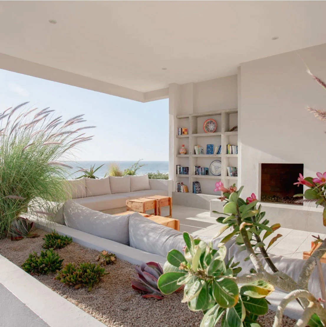 A Patio in Mexico overlooks the ocean and has a fireplace, artsy bookshelves, and is surrounded by planters