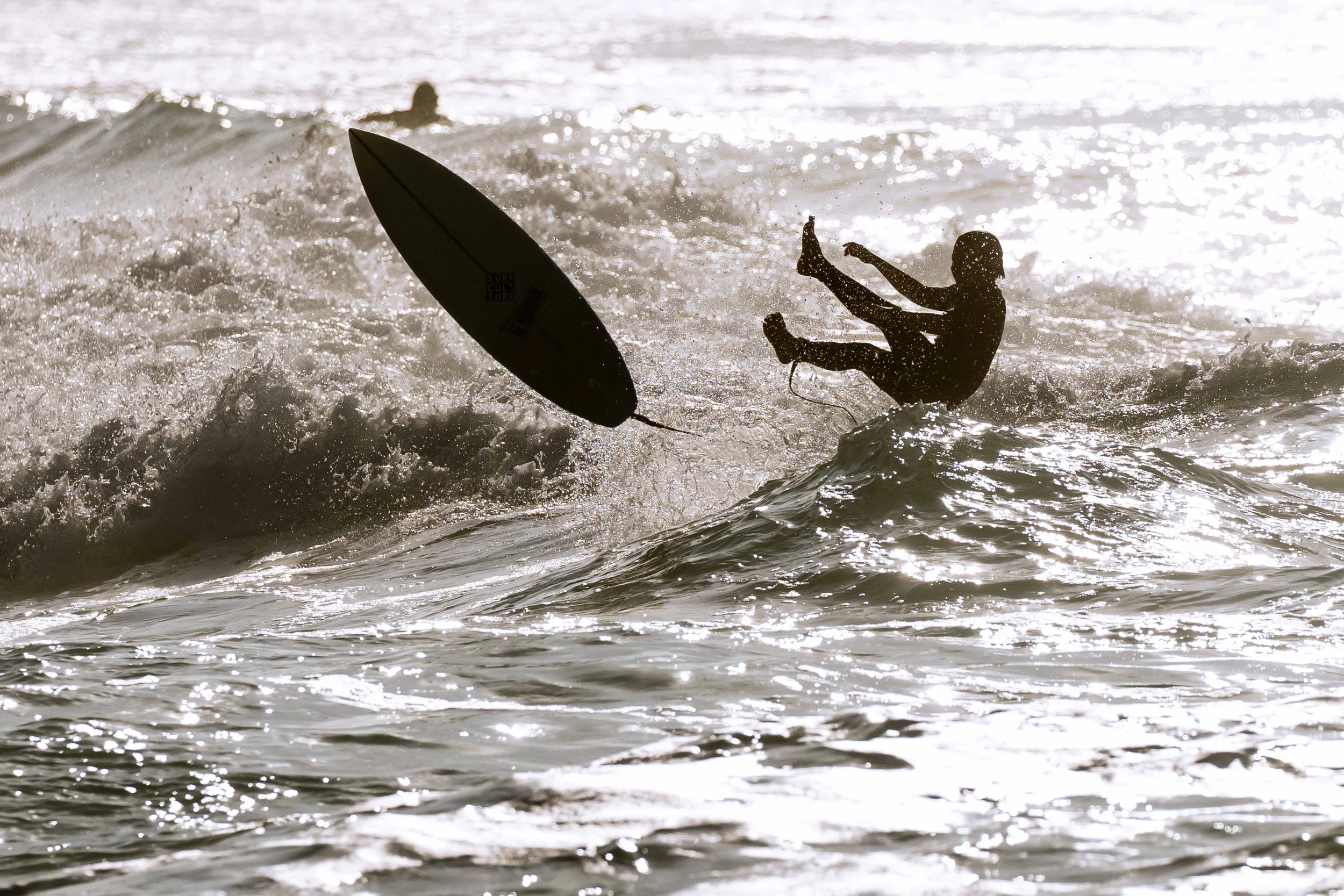 Surfer falls off his surfboard into the sea while trying to catch waves at Bondi Beach, Sydney, Australia.