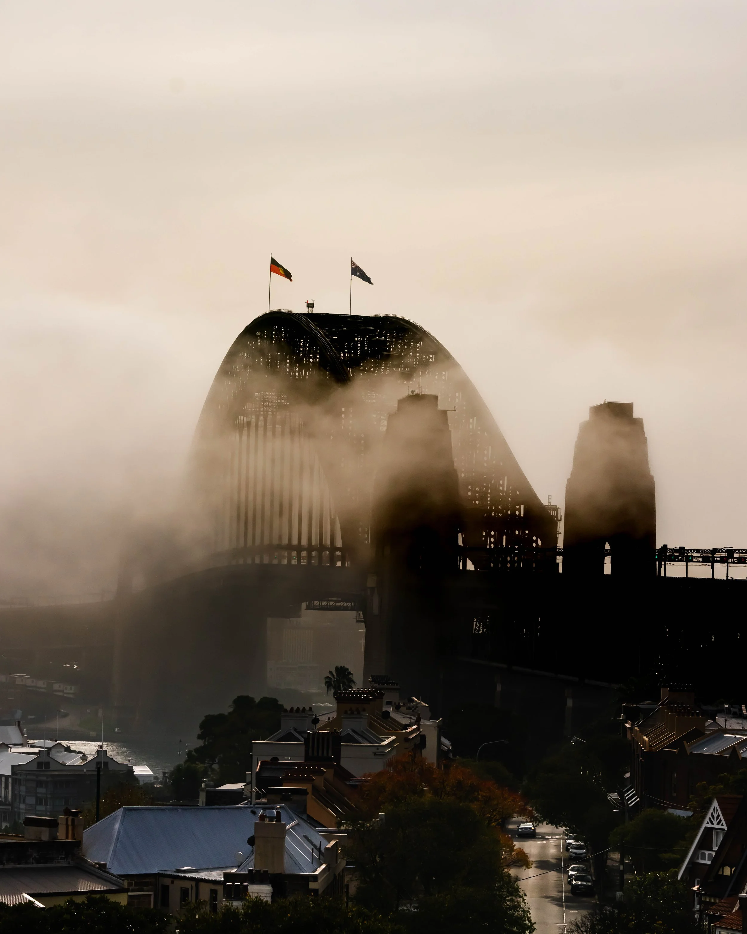 Sydney Harbour Bridge surrounded by fog at sunrise