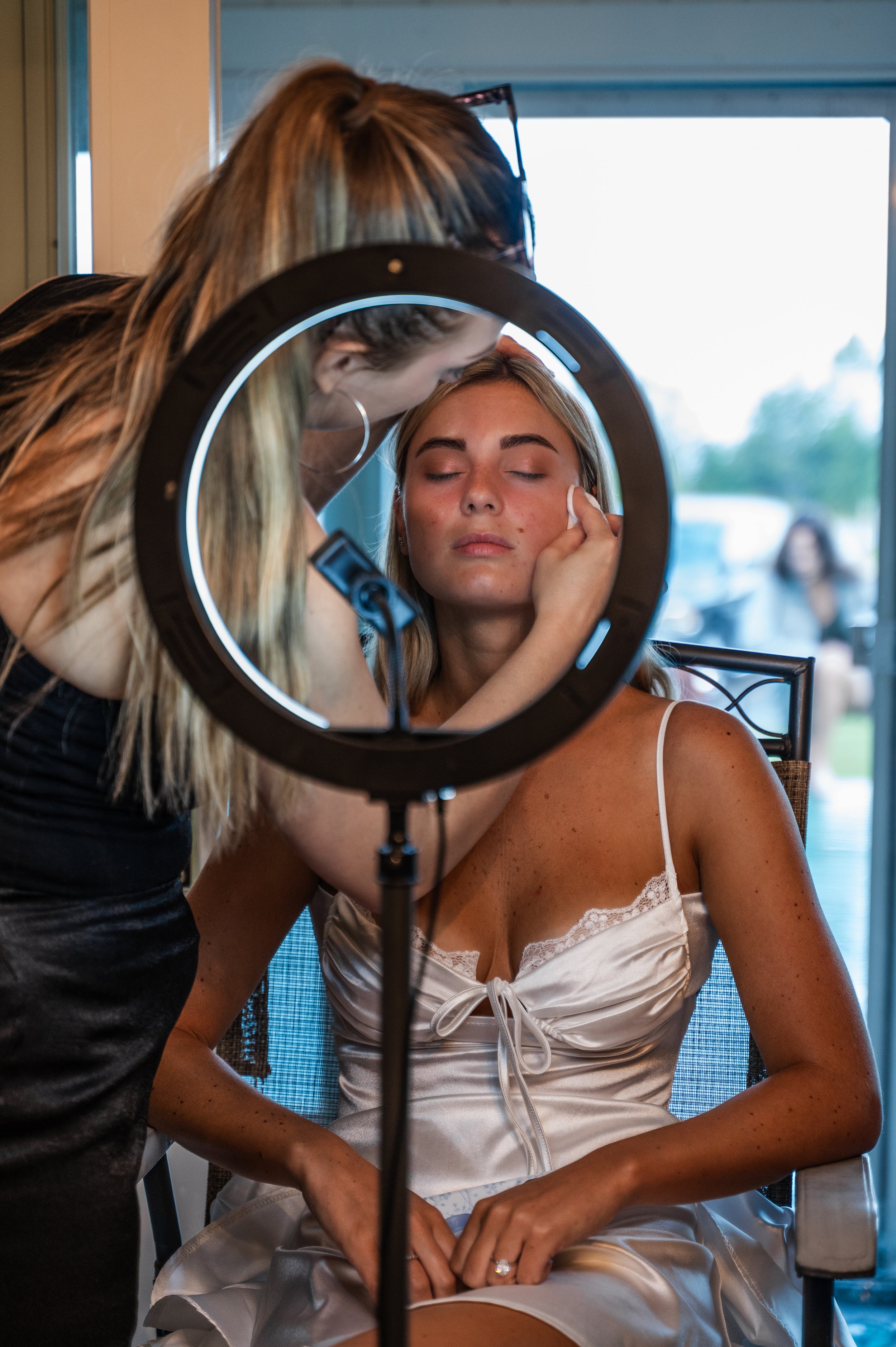 A bridesmaid has her makeup done through a ring light during the wedding morning in Petoskey, Michigan.