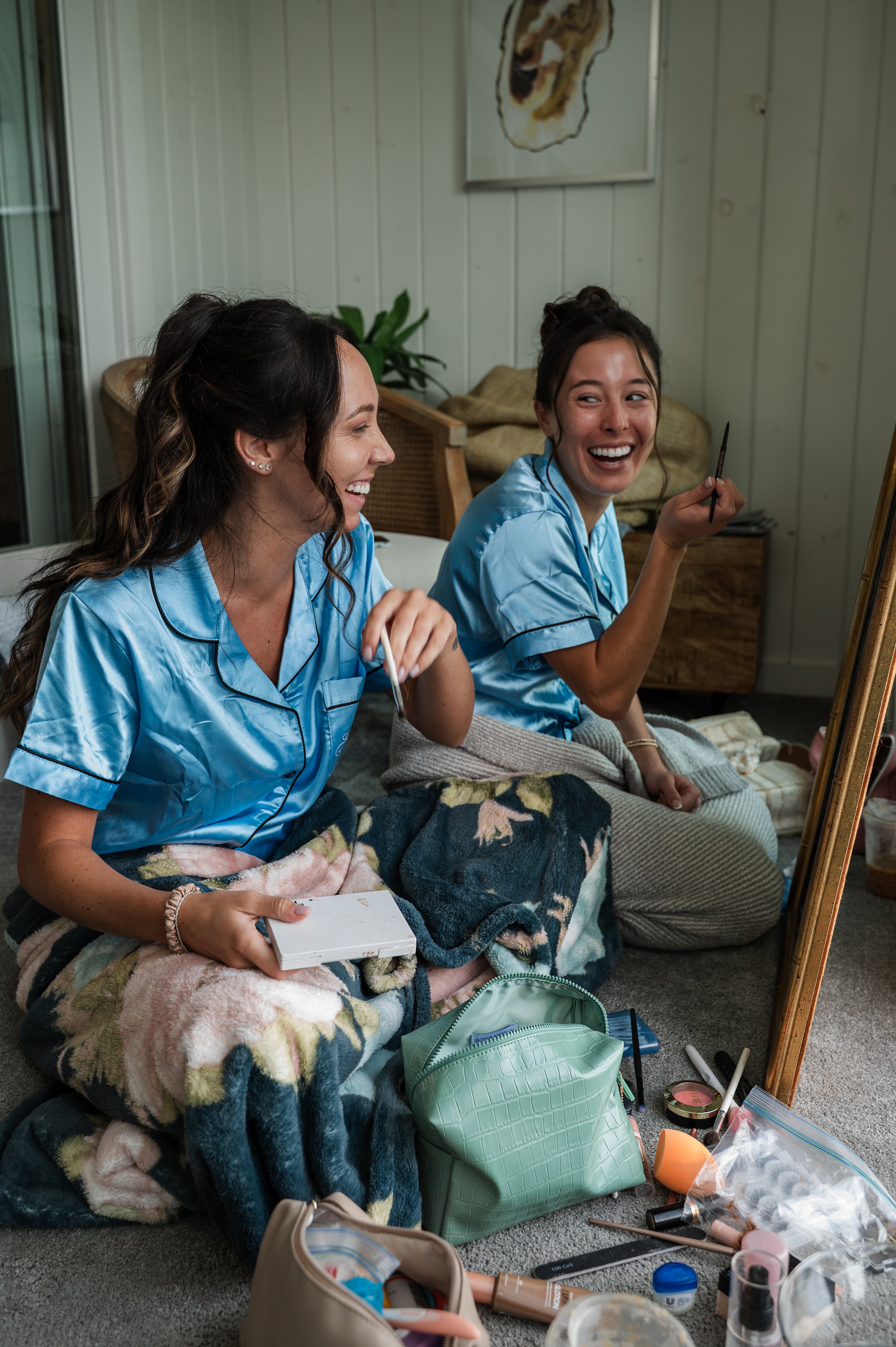 Bridesmaids laugh together while getting ready at Bay Inn of Petoskey.
