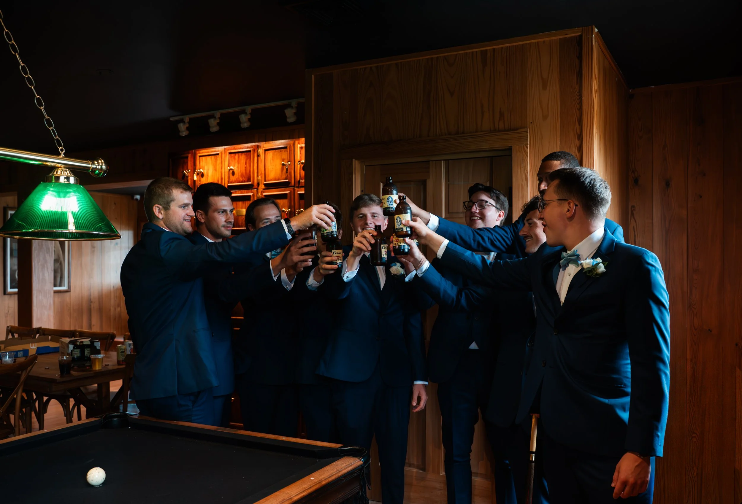 Matt and his groomsmen raise their drinks around the pool table at Gypsy Distillery in Petoskey, Michigan.