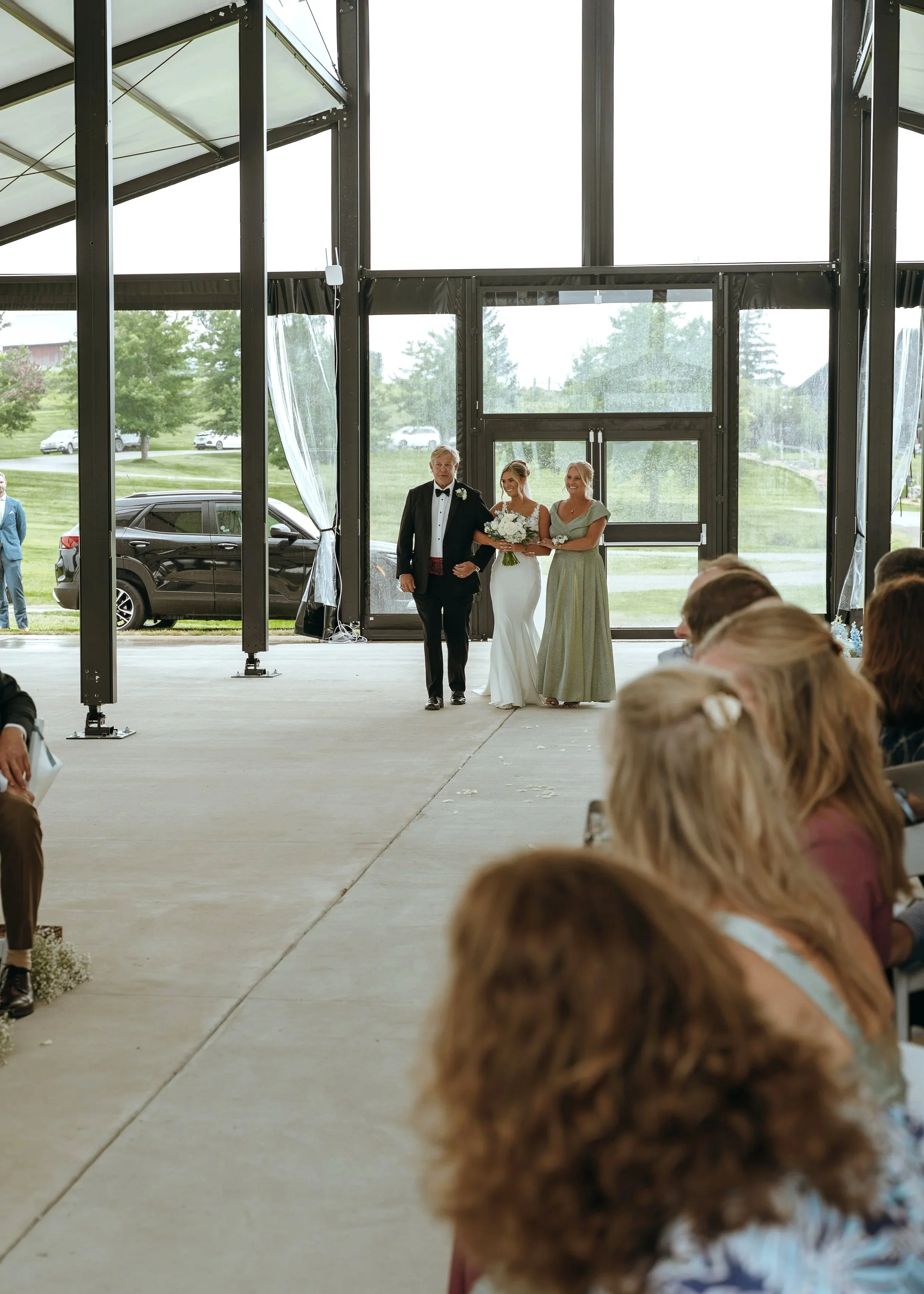The wedding processional begins inside the covered ceremony space at Gypsy Distillery in Petoskey, Michigan.