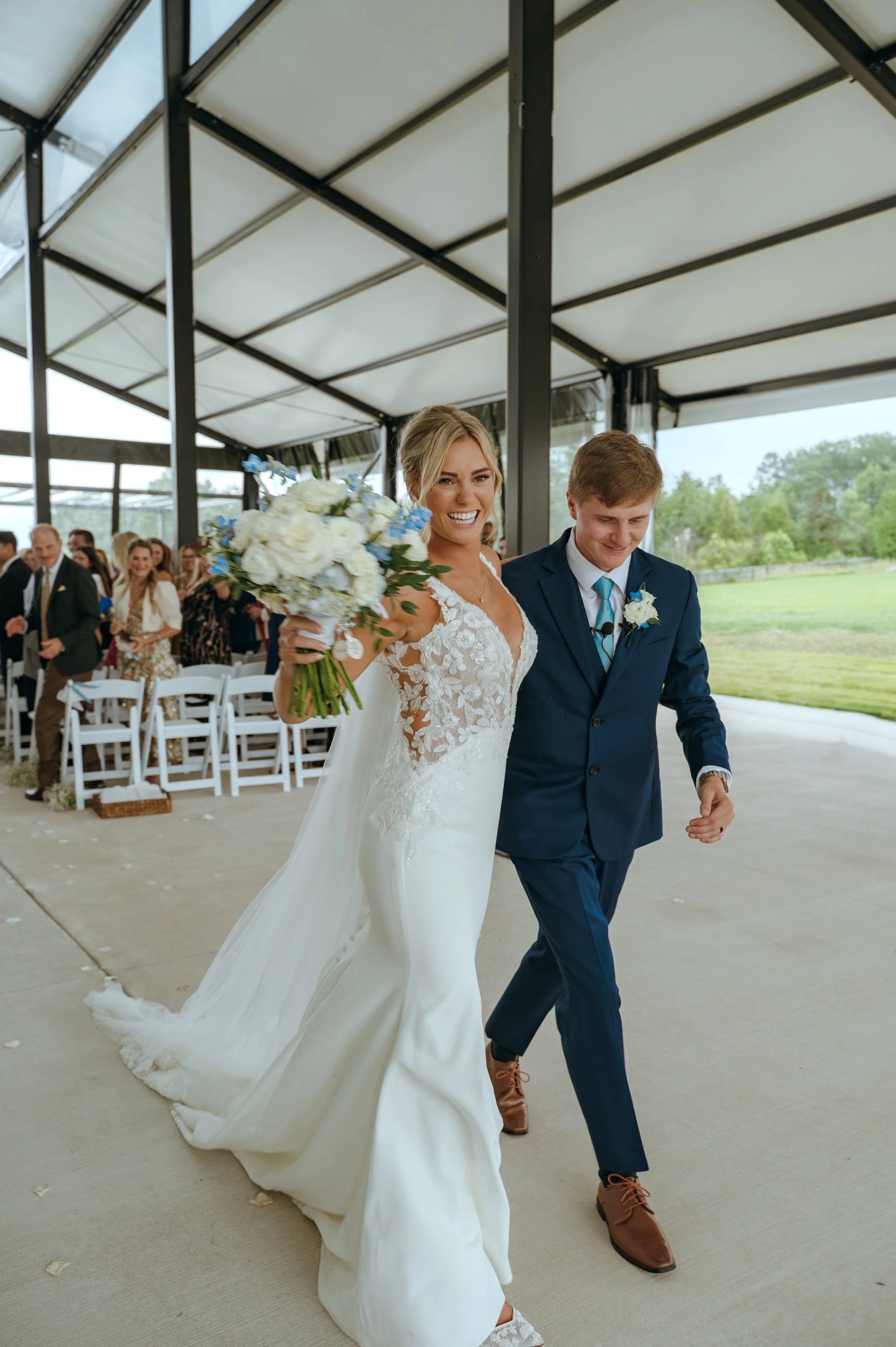 Sydney and Matt smile as they walk back up the aisle together after their Petoskey wedding ceremony.