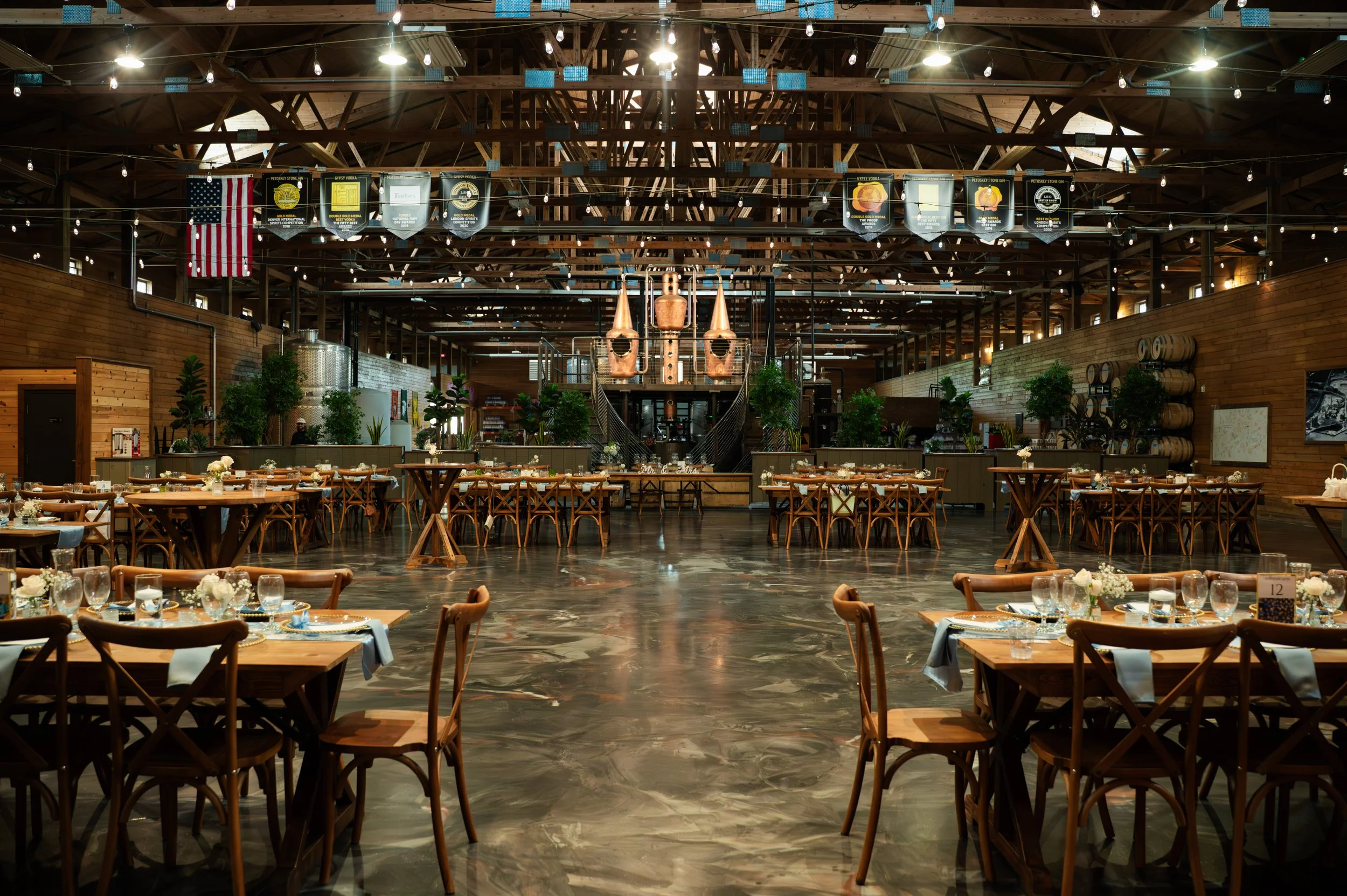 Wedding reception tables arranged inside Gypsy Distillery in Petoskey, Michigan.