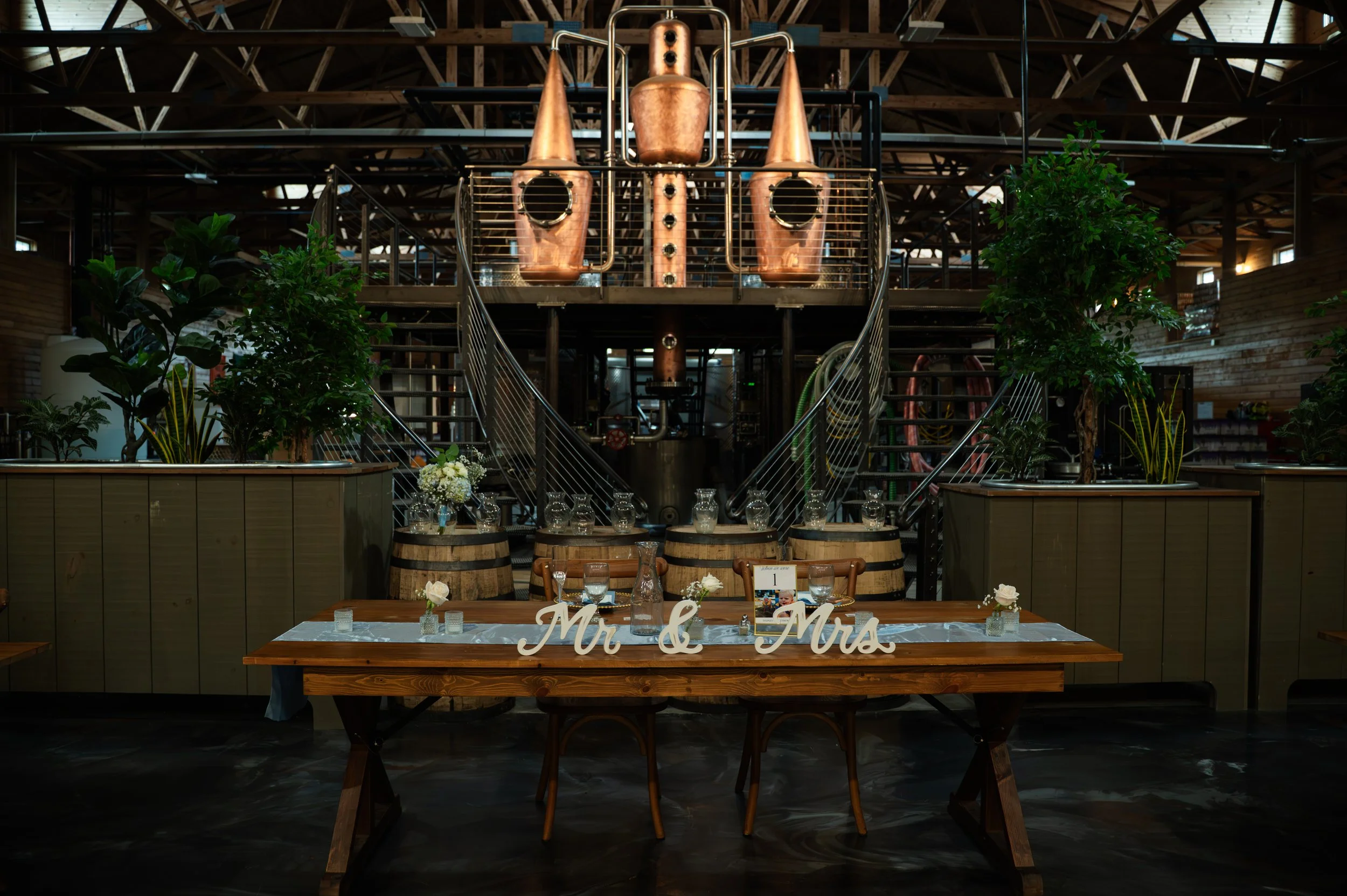 Sydney and Matt’s sweetheart table displayed beneath the copper stills at Gypsy Distillery.