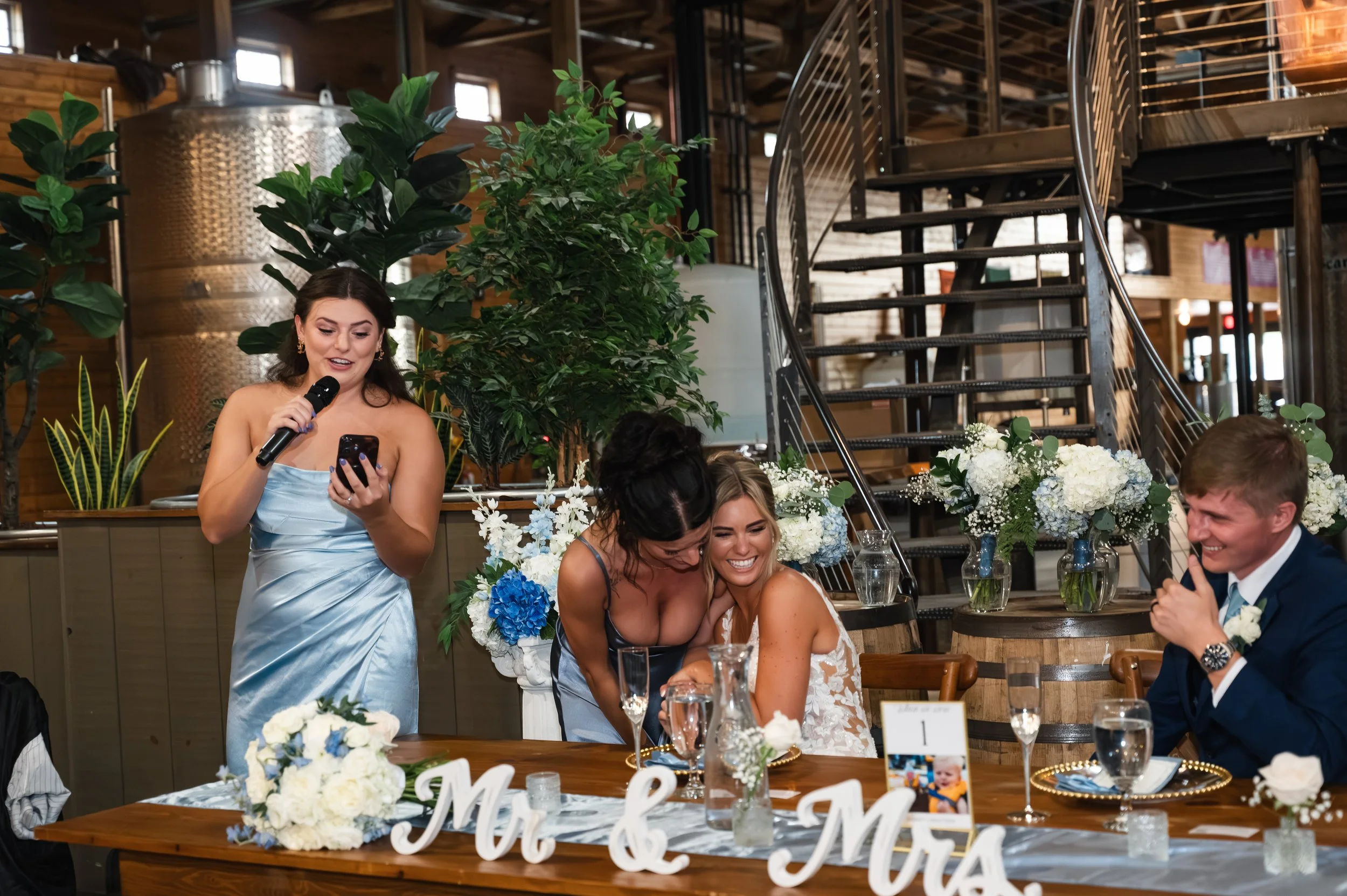 Sydney and Matt laugh during a maid of honor speech at their Gypsy Distillery wedding reception.