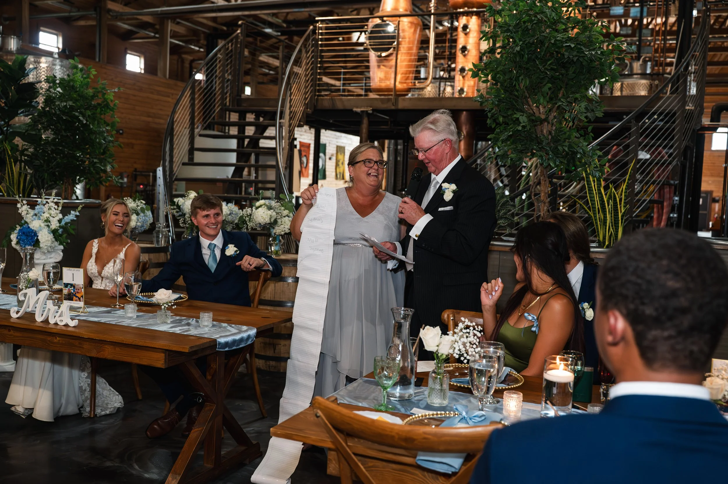 Two guests share a wedding speech while Sydney and Matt listen at their Gypsy Distillery reception.