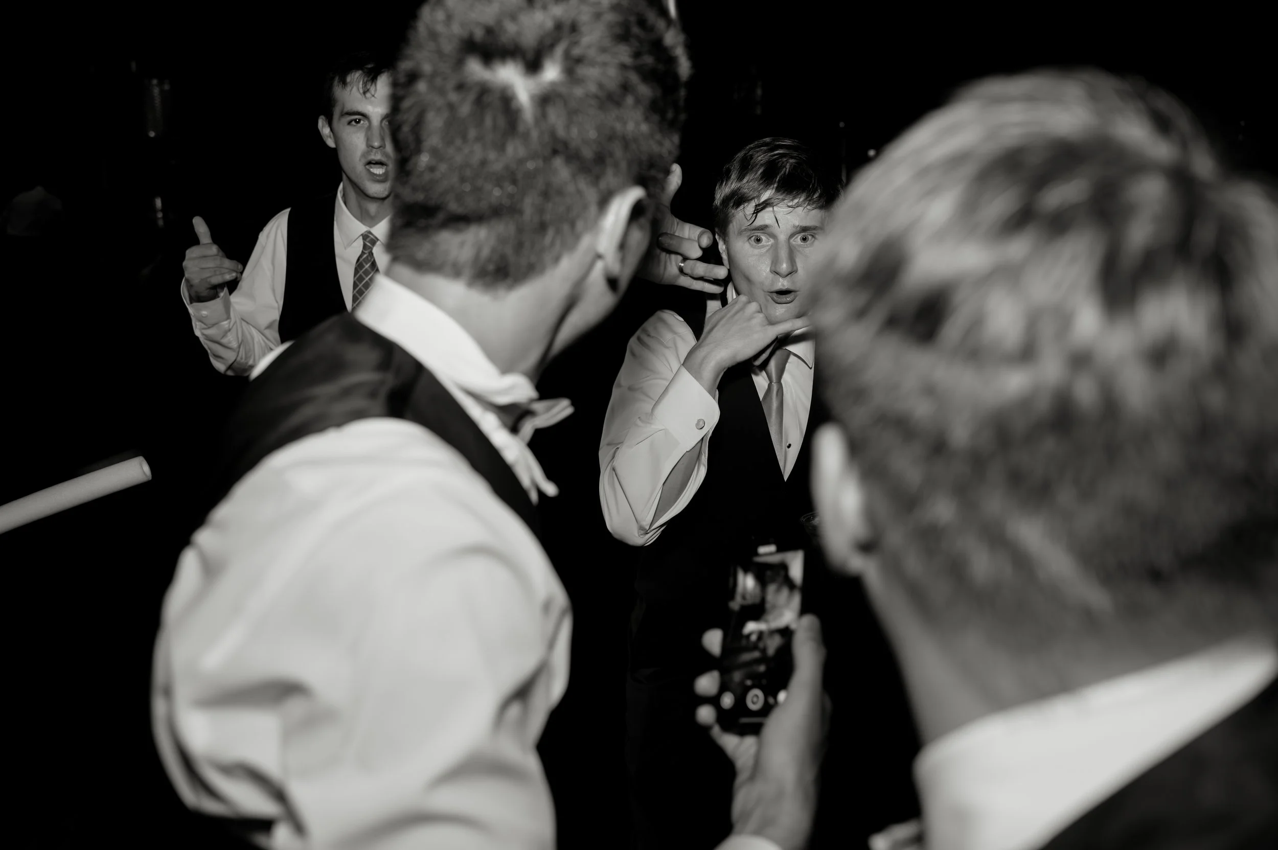Groomsmen make playful expressions on the dance floor during Sydney and Matt’s Gypsy Distillery wedding reception.