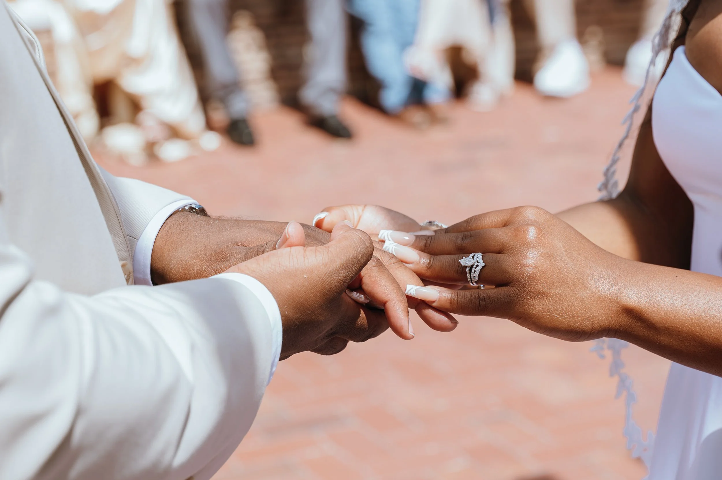 Close-up of Anndi and Diego exchanging wedding rings during their ceremony.
