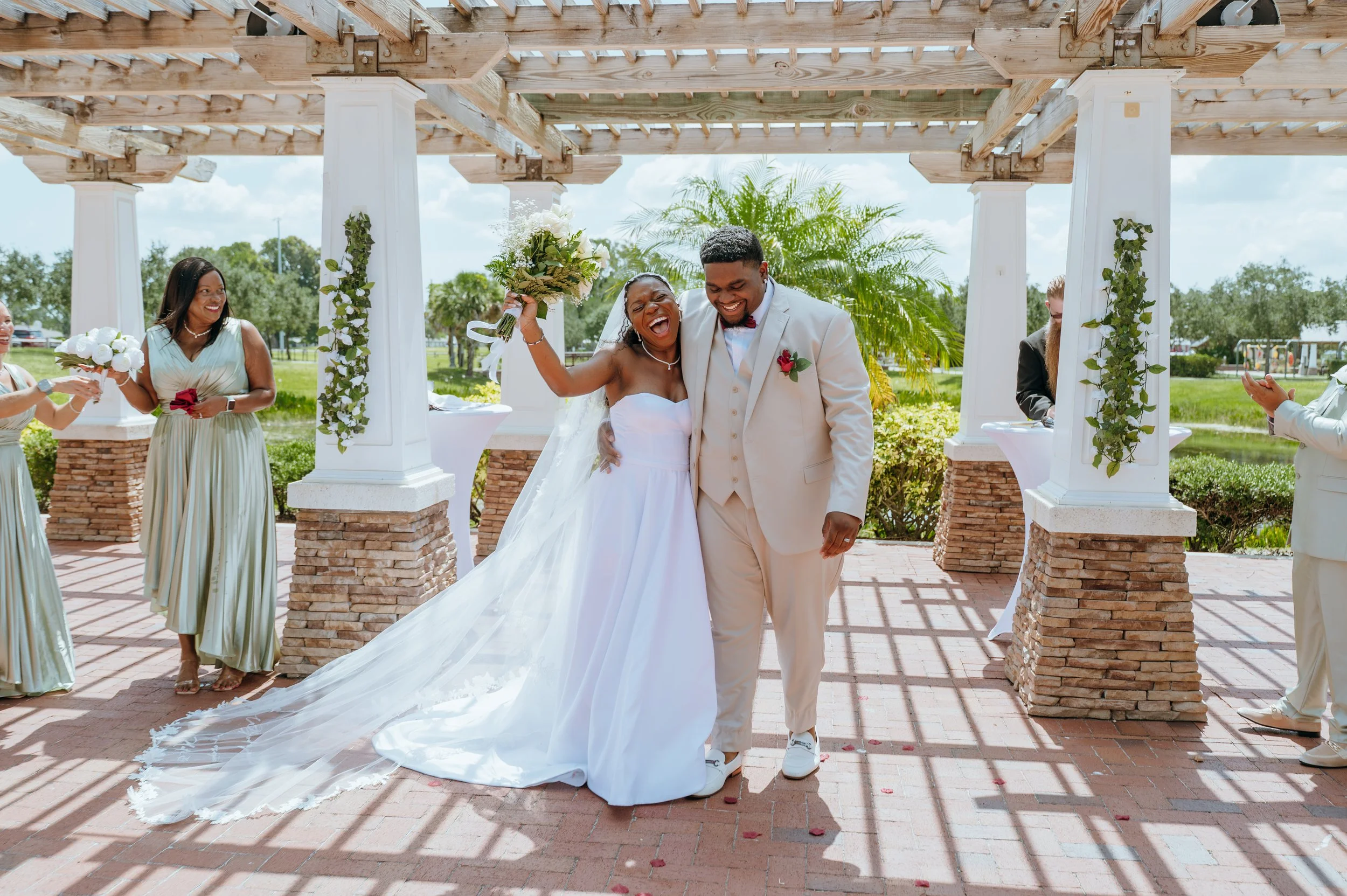 Anndi raising her white rose bouquet as she and Diego celebrate becoming husband and wife.