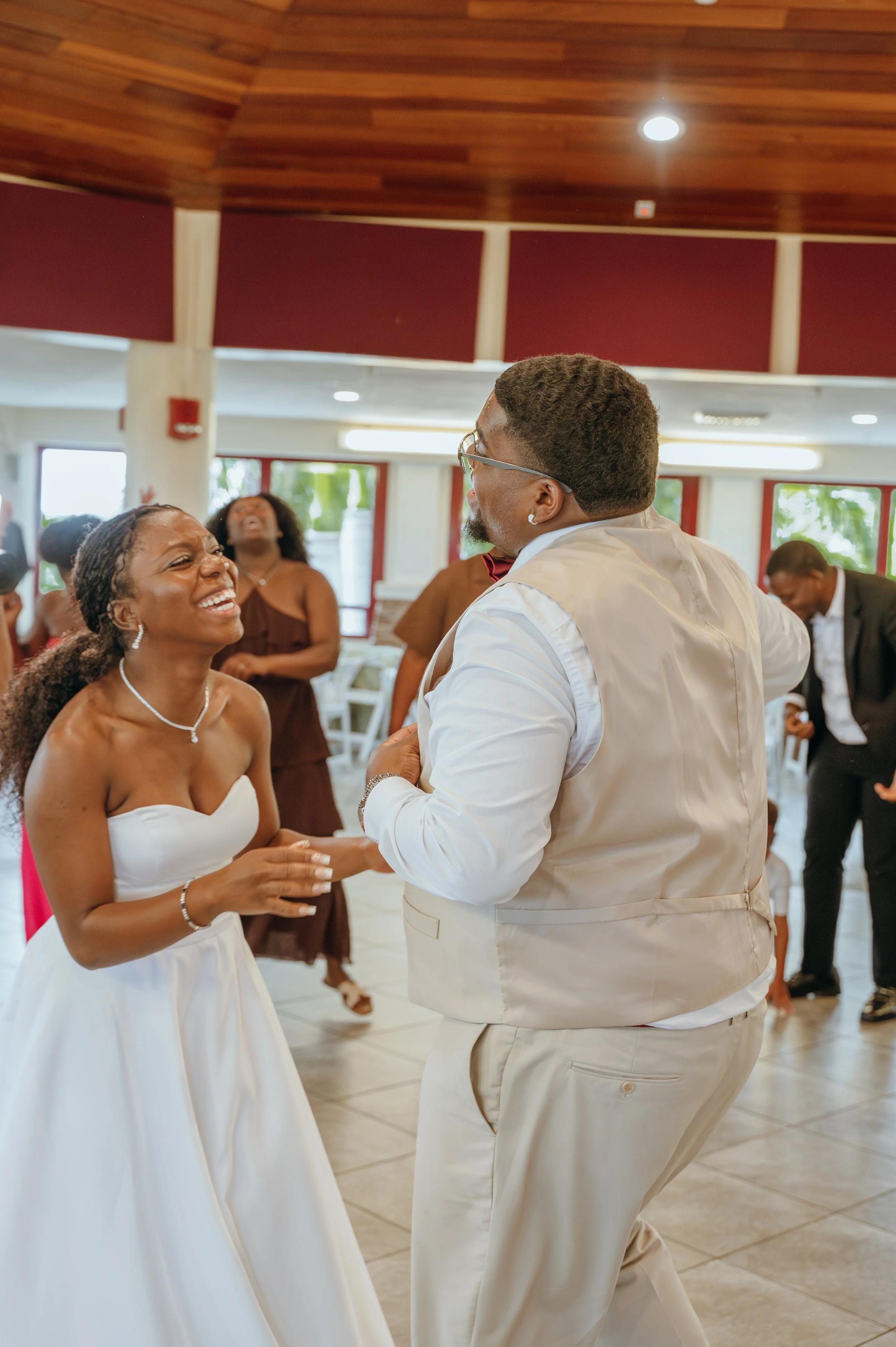 Anndi and Diego laugh together while dancing at their wedding reception.