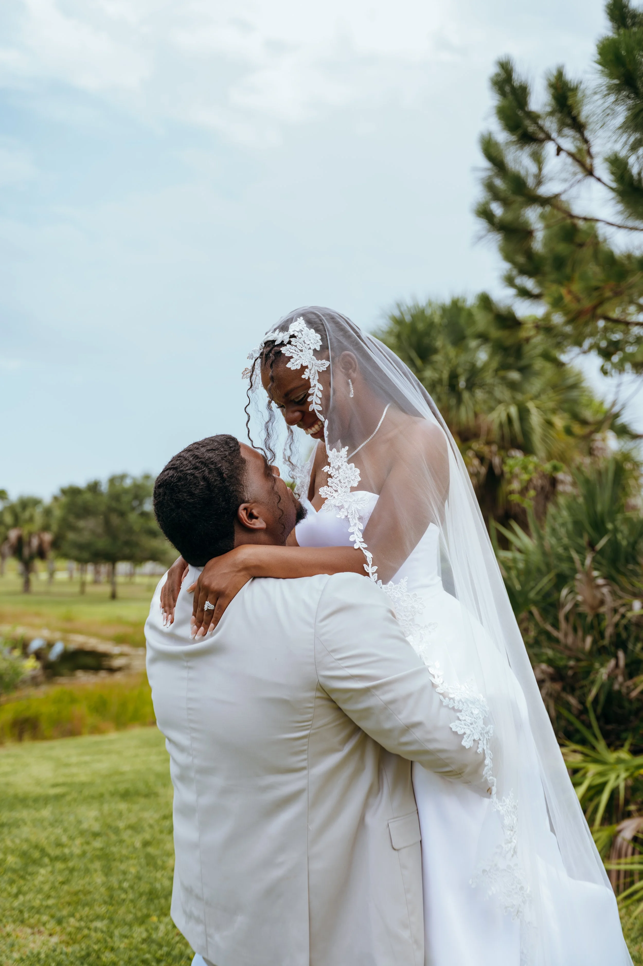 Diego lifting Anndi into his arms during their outdoor wedding portraits.