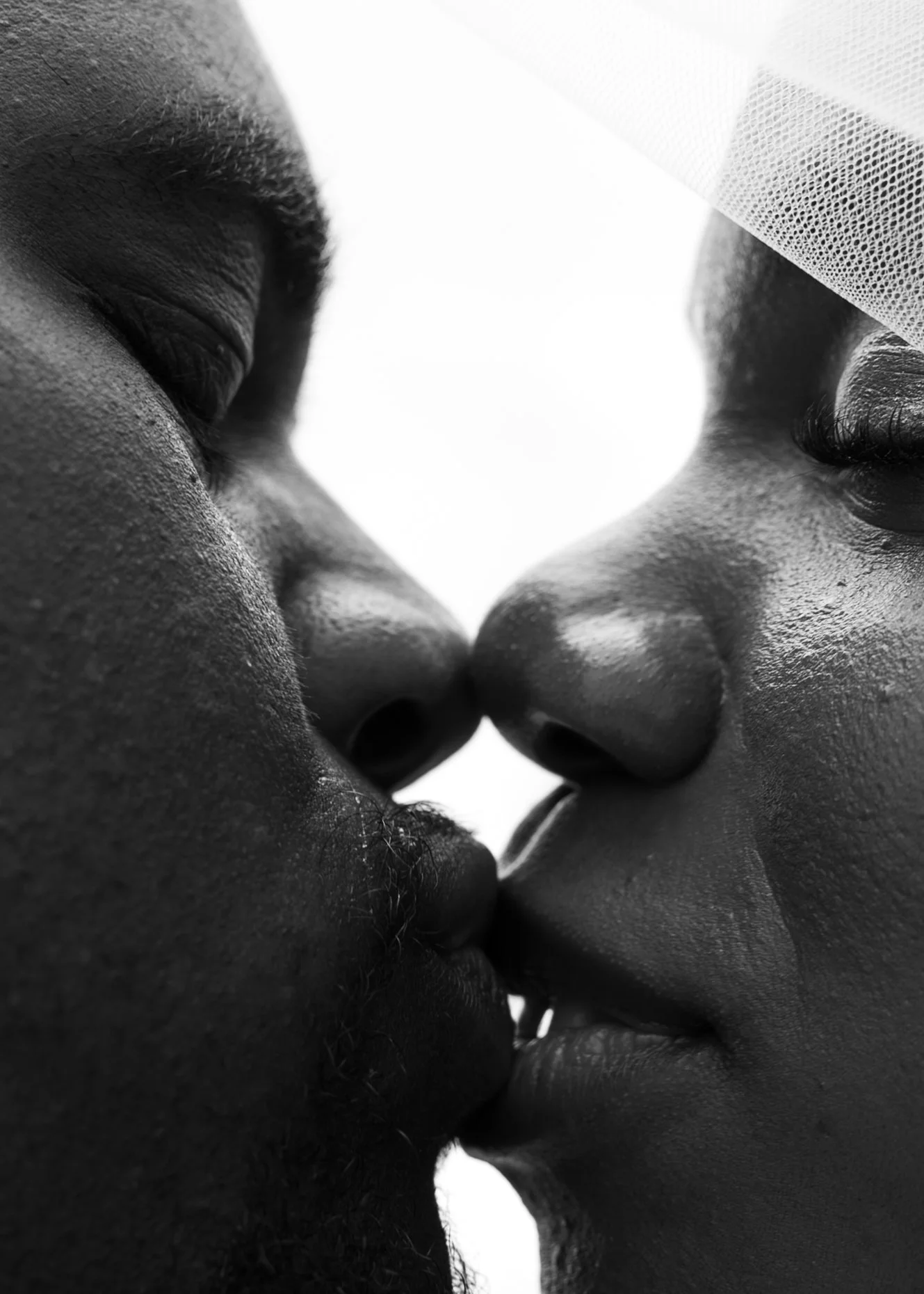 Artistic black-and-white close-up of Anndi and Diego sharing a kiss.