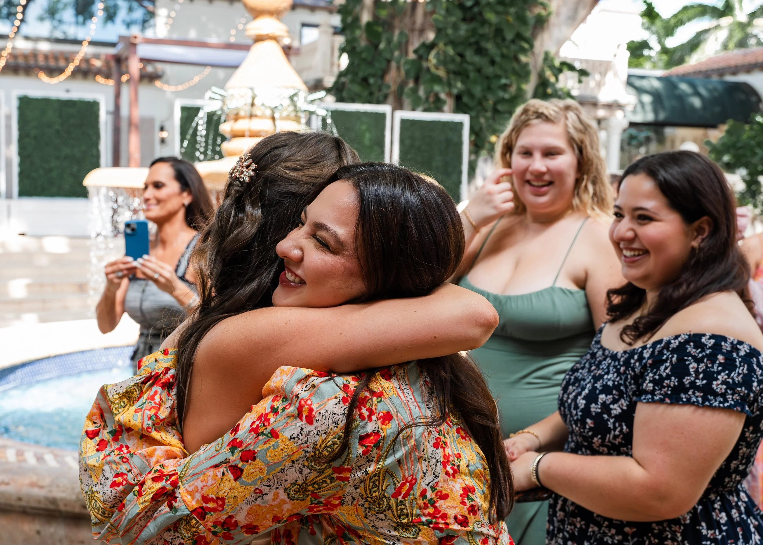 Guests sharing a joyful hug during a bridal shower at The Addison in Boca Raton.