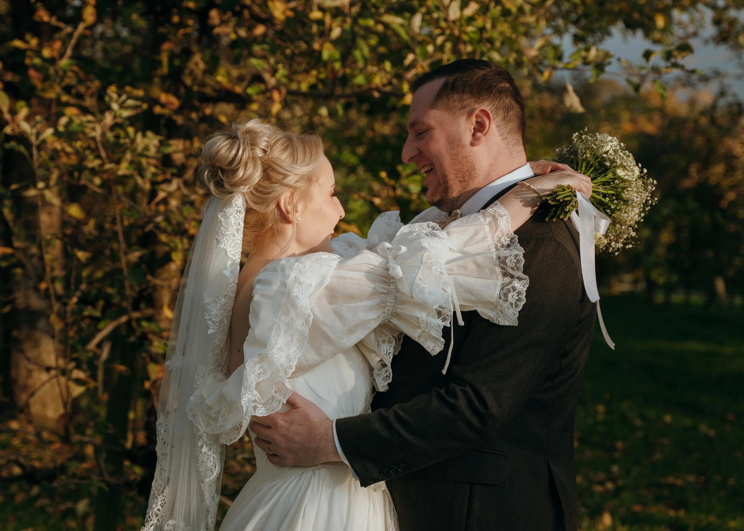 Bride and groom embracing in an apple orchard during their destination wedding in Rapperswil-Jona, Switzerland