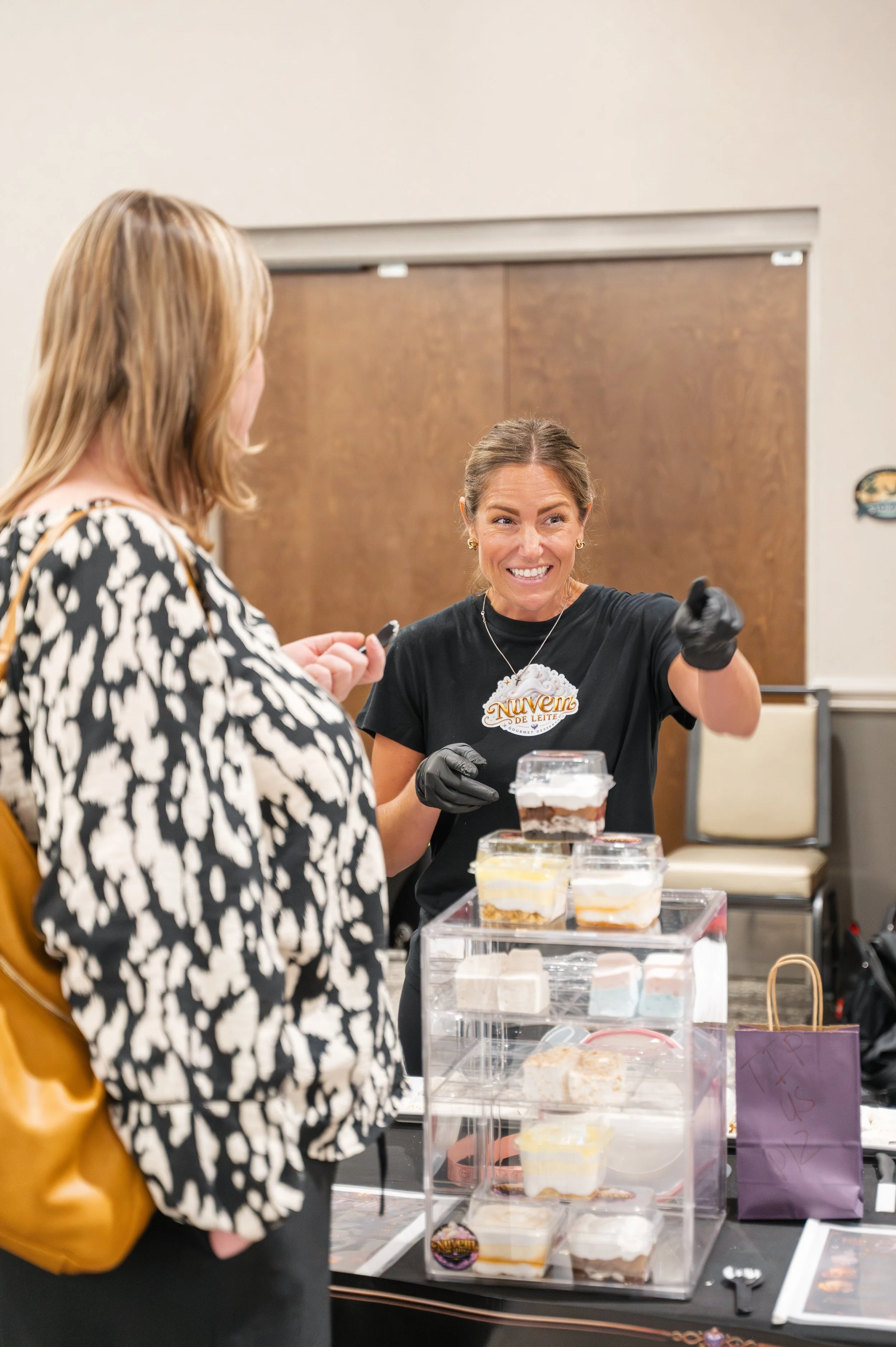 Local vendor smiling while serving a guest at Whimsy Market in Lake County Florida at the Venetian Center.