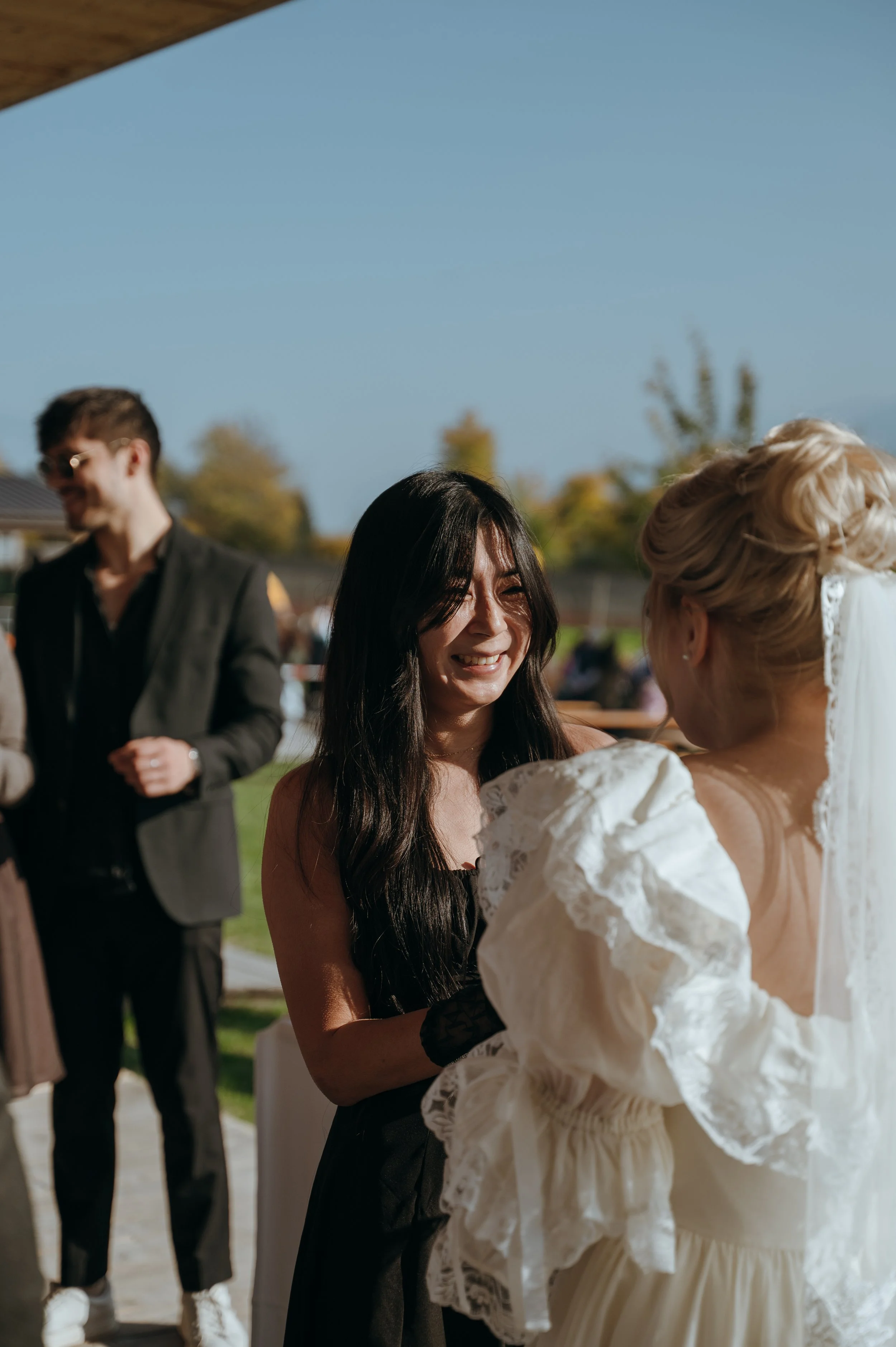 Malwina sharing a candid conversation with a guest during cocktail hour at her Switzerland wedding