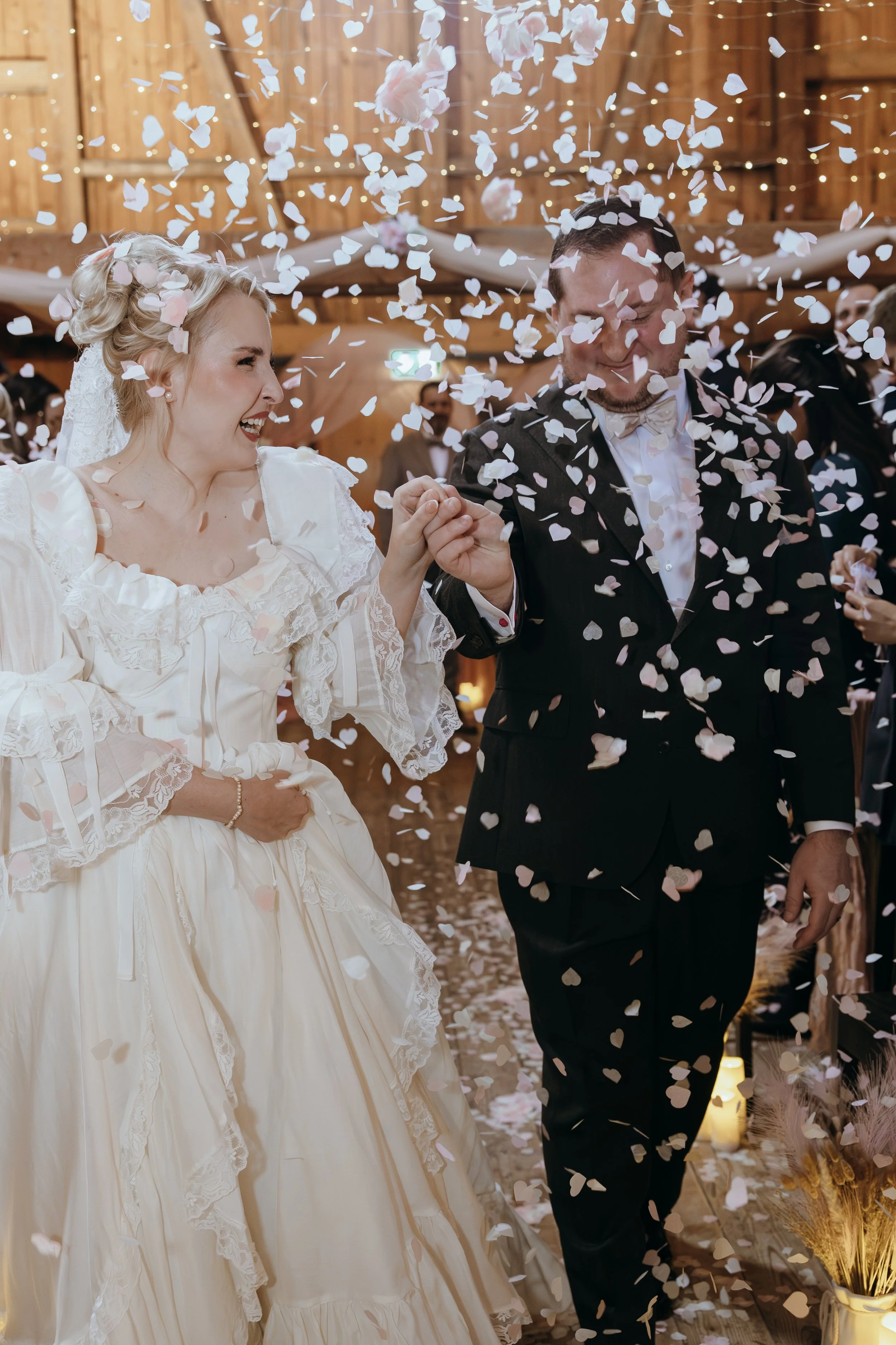 Newlyweds celebrating beneath falling confetti after their Switzerland wedding ceremony