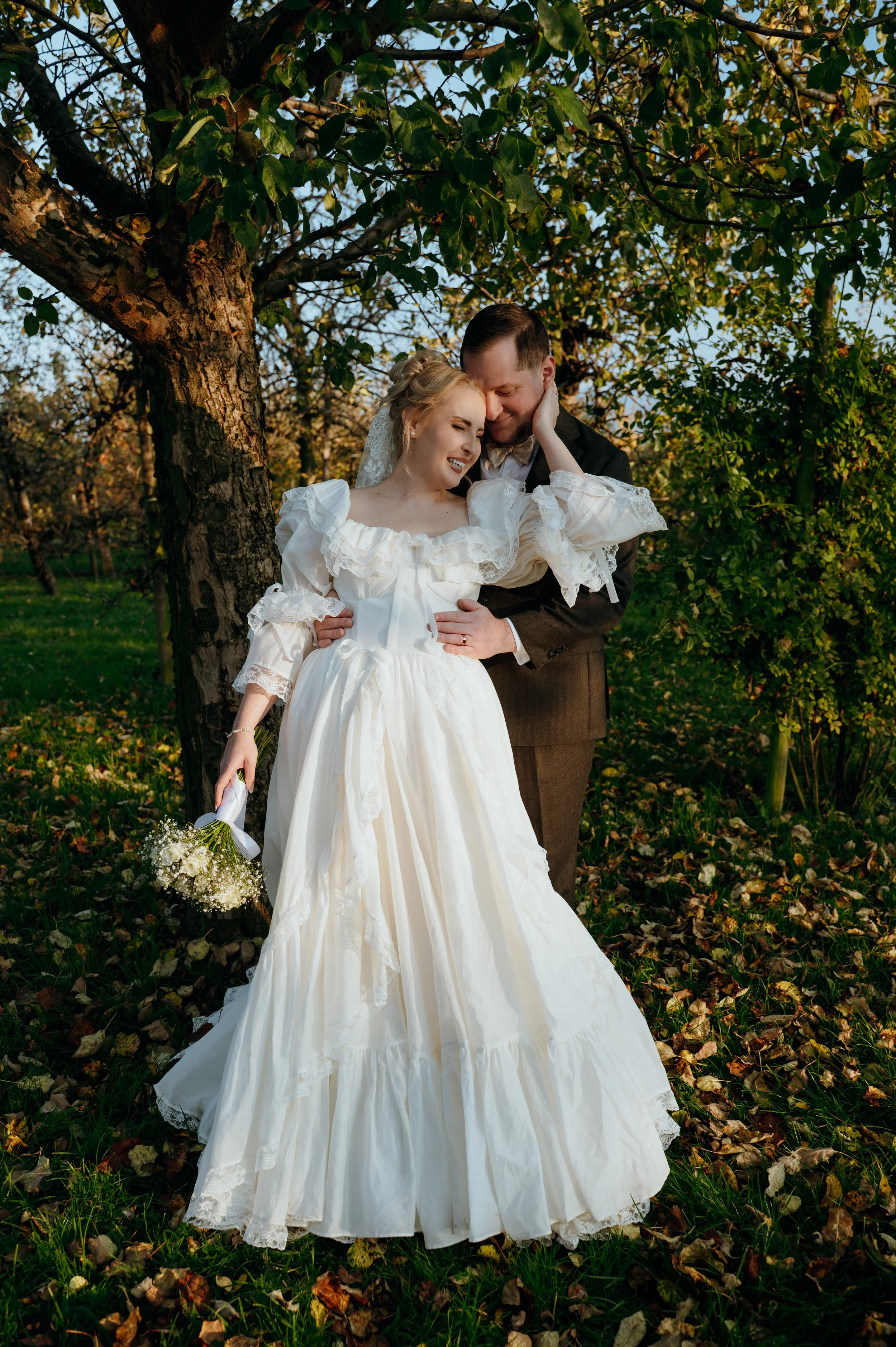 Bride and groom embracing beneath a tree in Rapperswil-Jona, Switzerland