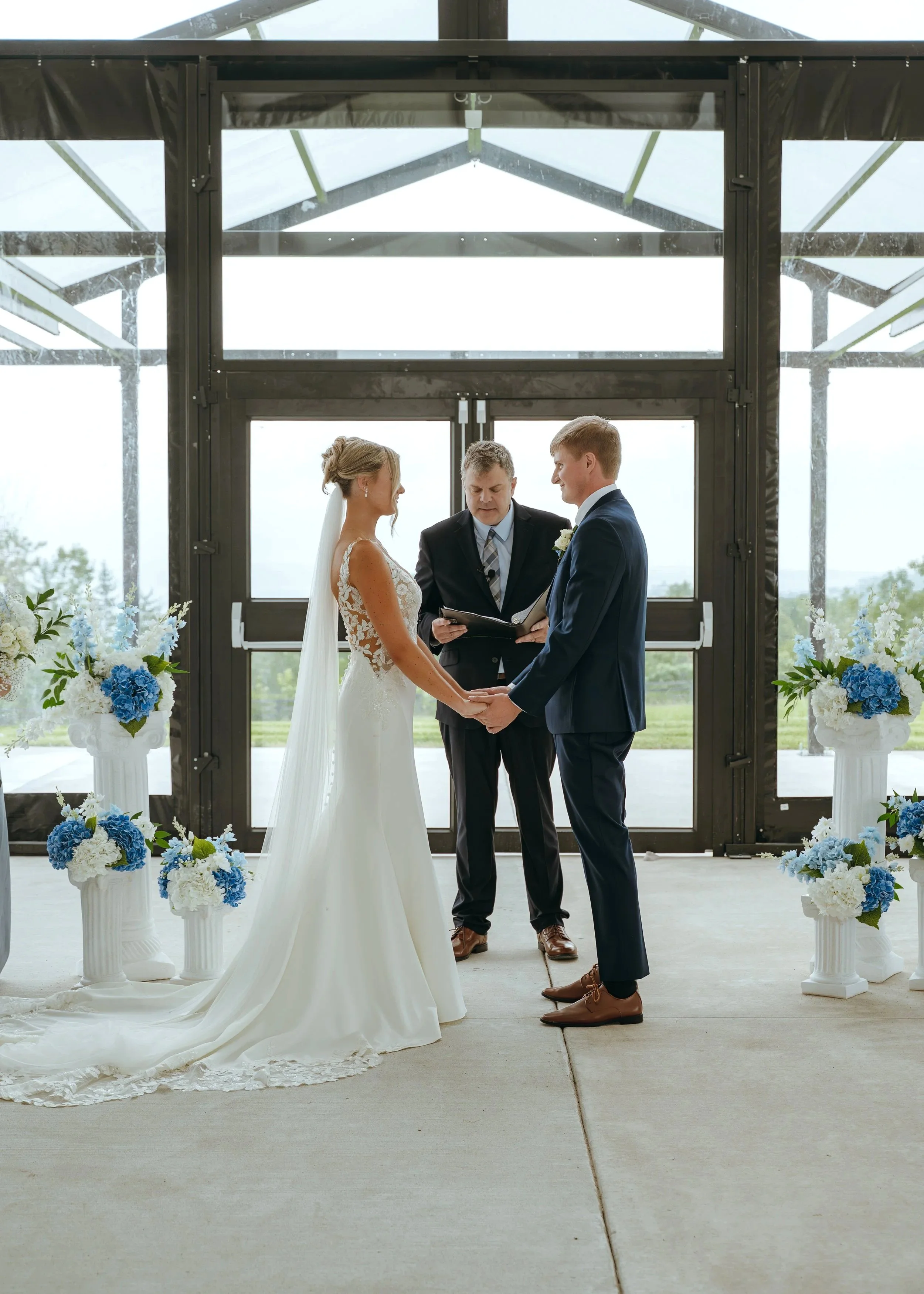 Sydney and Matt stand together during their covered wedding ceremony at Gypsy Distillery in Petoskey, Michigan.