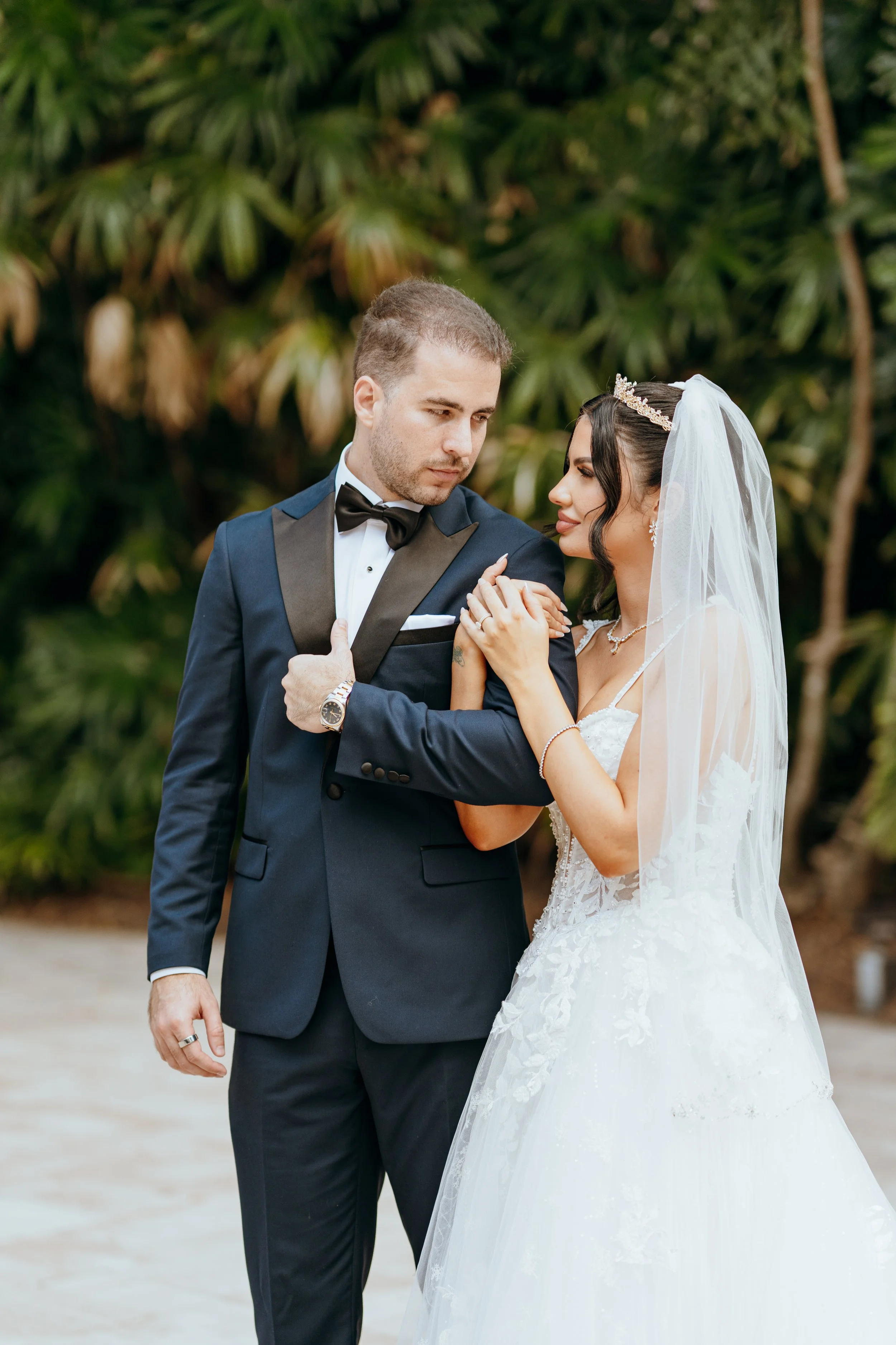 Bride and groom sharing a quiet wedding portrait surrounded by tropical greenery in South Florida
