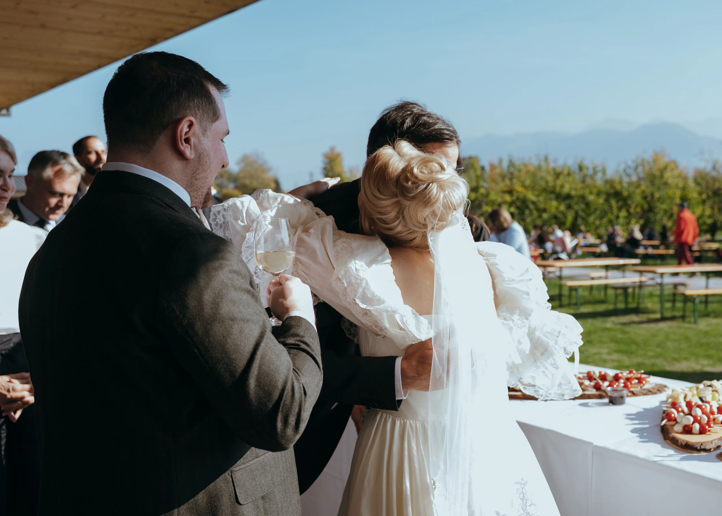 Malwina warmly embracing a guest during the outdoor cocktail hour at her Switzerland wedding