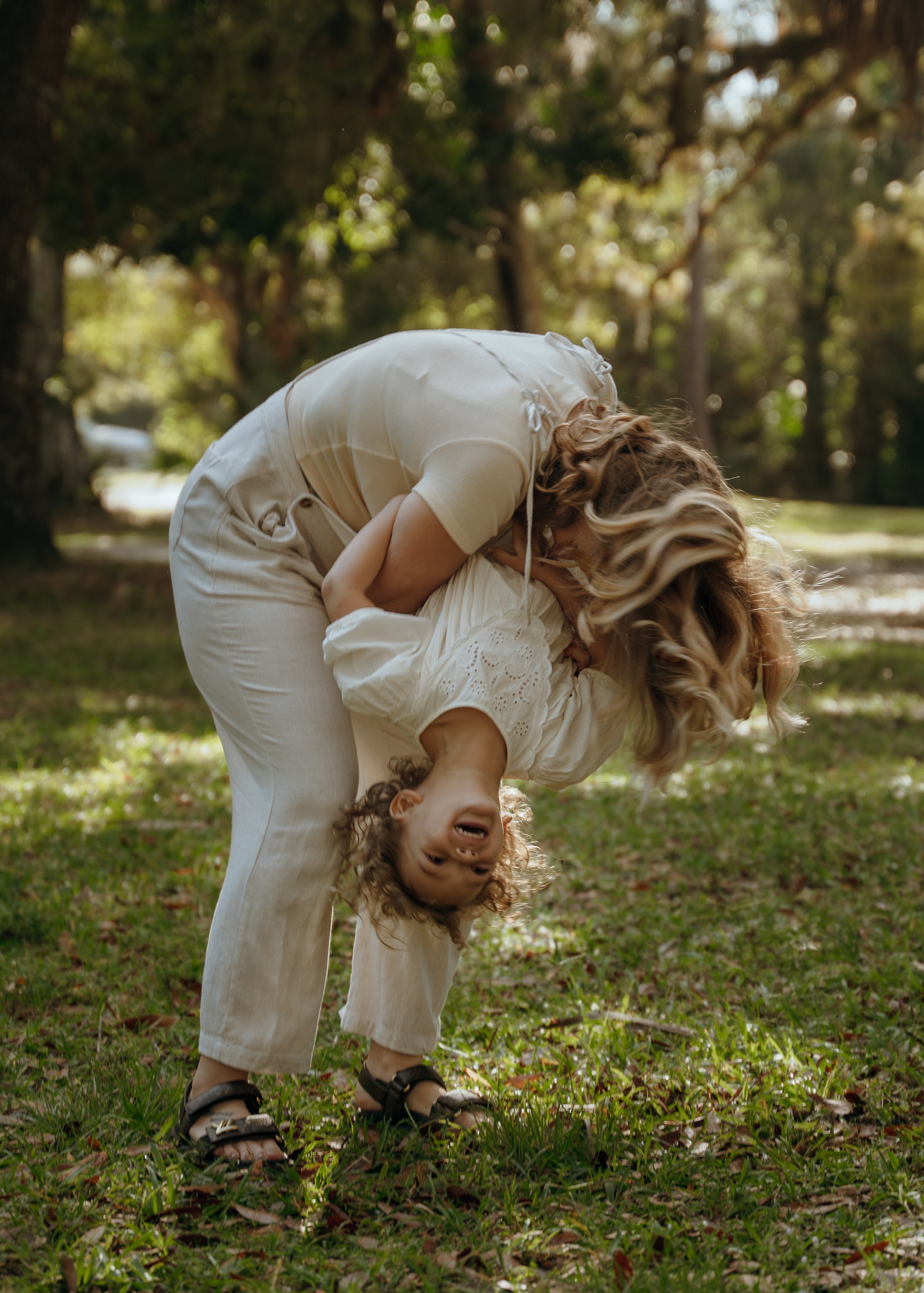 Mother playing with her young daughter during a candid family photography session at Riverbend Park in Jupiter, Florida