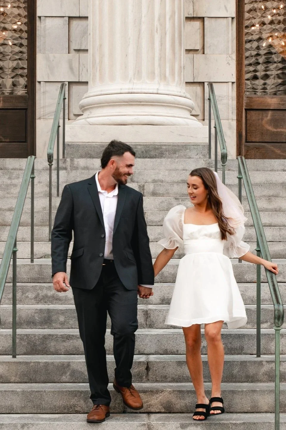 Newlyweds walk down the courthouse steps after their intimate Florida wedding ceremony.