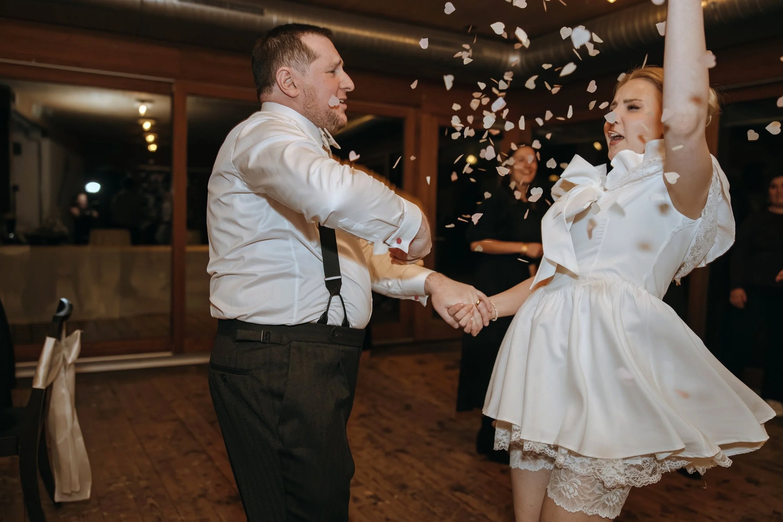 Malwina dancing with a guest as flower petals fill the air during her wedding reception at Jucker Farm.