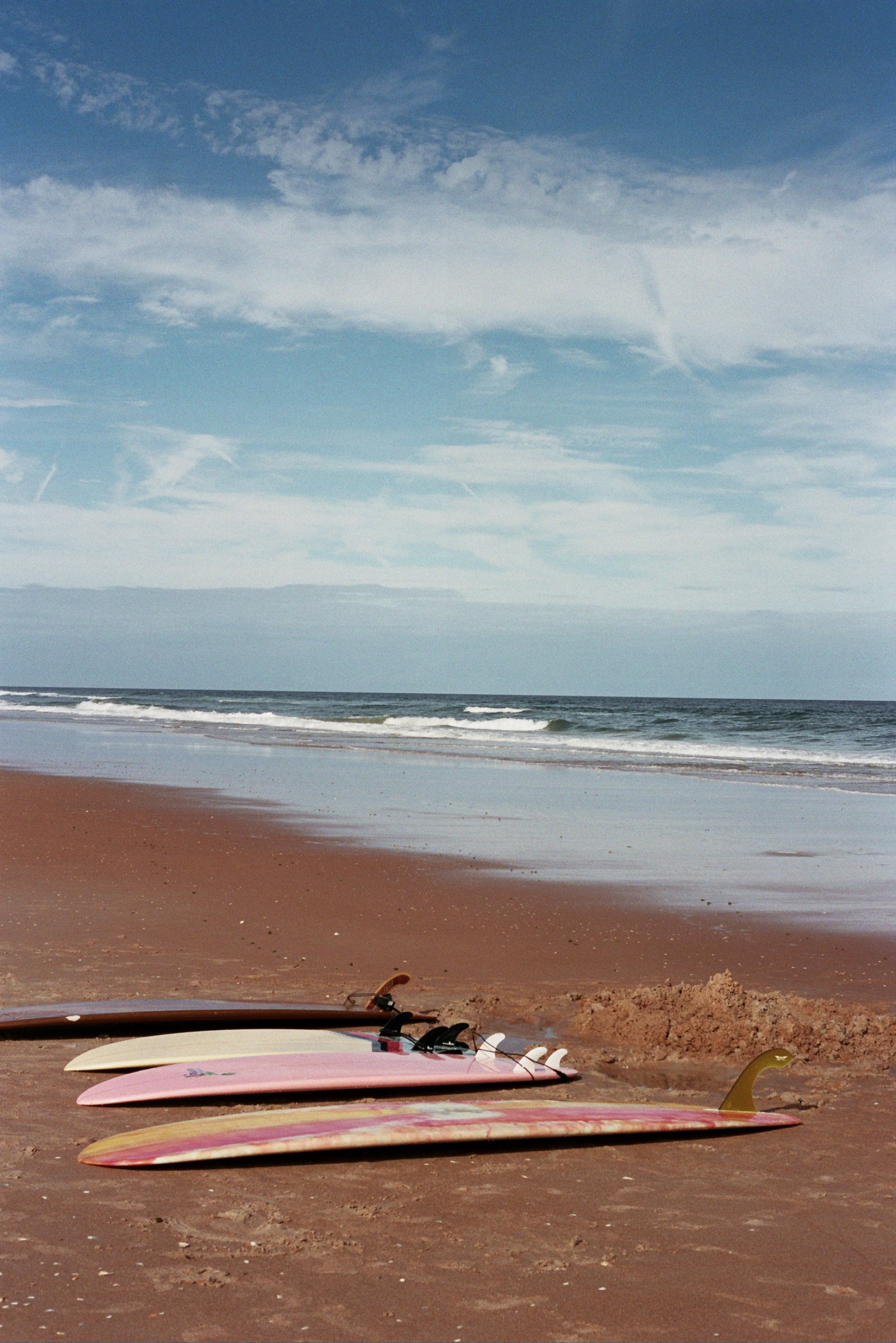  All of our boards lined up on the beach 