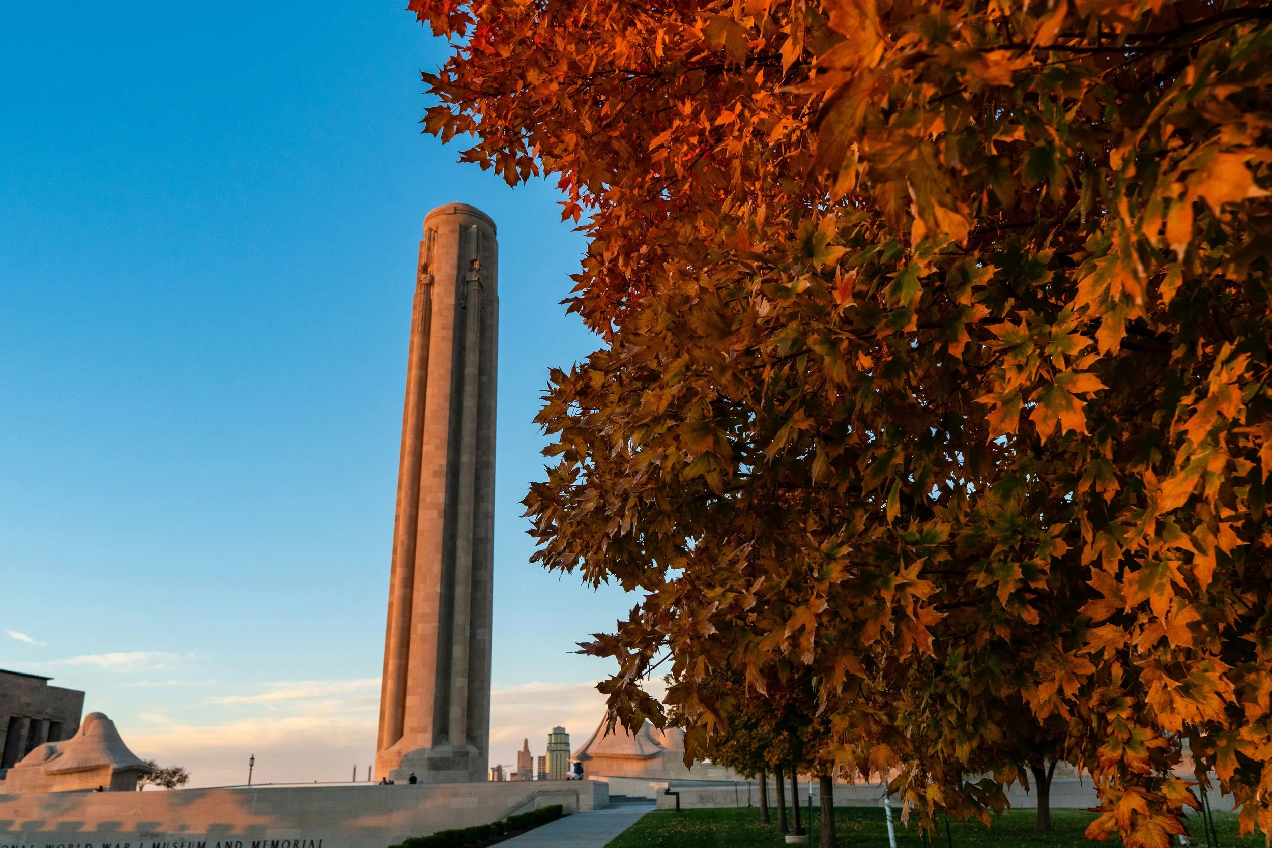 Liberty Memorial in Kansas City during the fall, with autumn leaves surrounding the iconic structure, offering a serene and reflective atmosphere.