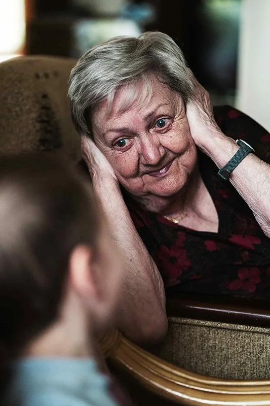 Elderly woman smiling warmly at a child, symbolizing intergenerational love, memory, and emotional healing.