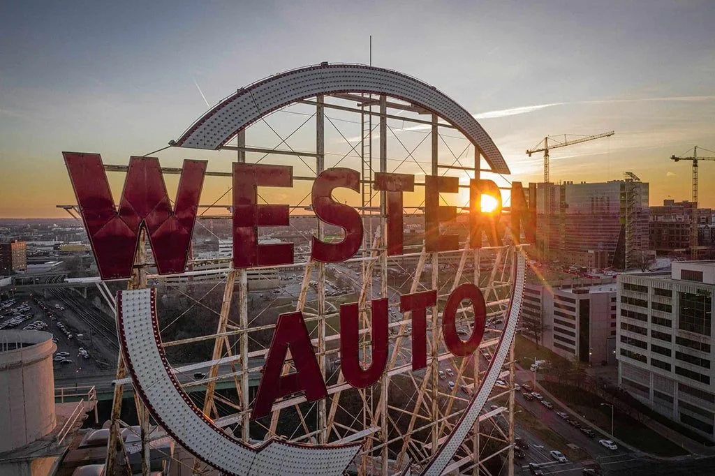 The historic Western Auto sign with the sunset in Kansas City in the background.