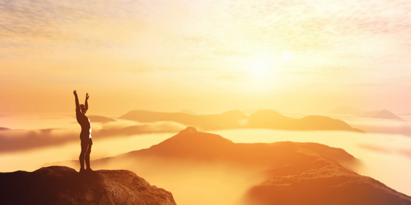 placebo effect man standing on top of mountain with arms in the air