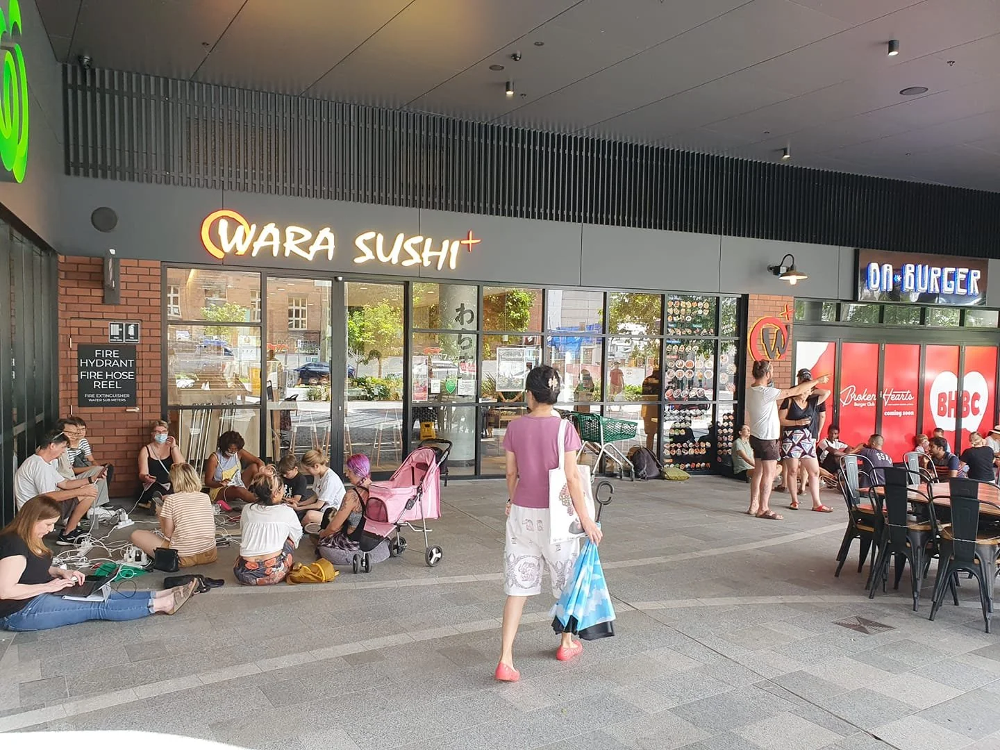 People gather in groups sitting and recharging their devices outside Montague Markets.
