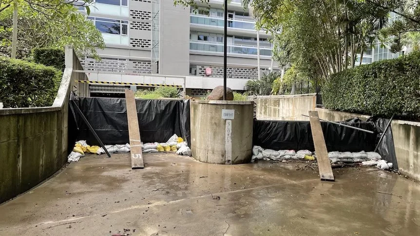 Flood planks and sandbags block an apartment block carpark entrance.