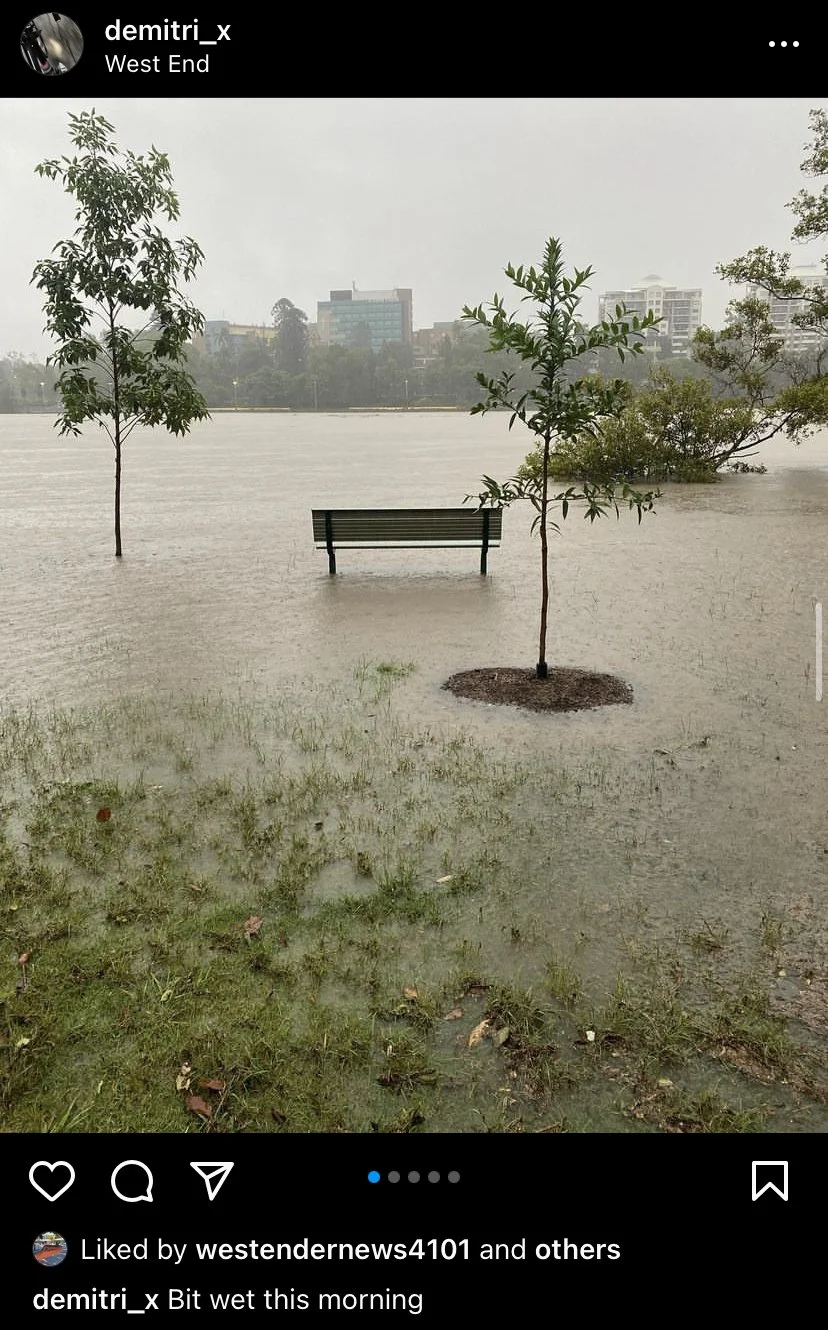 A riverside park bench surrounded by floodwaters.