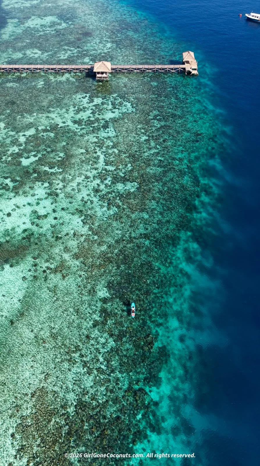 Traveler paddle boarding across The Seraya Reef in Komodo.