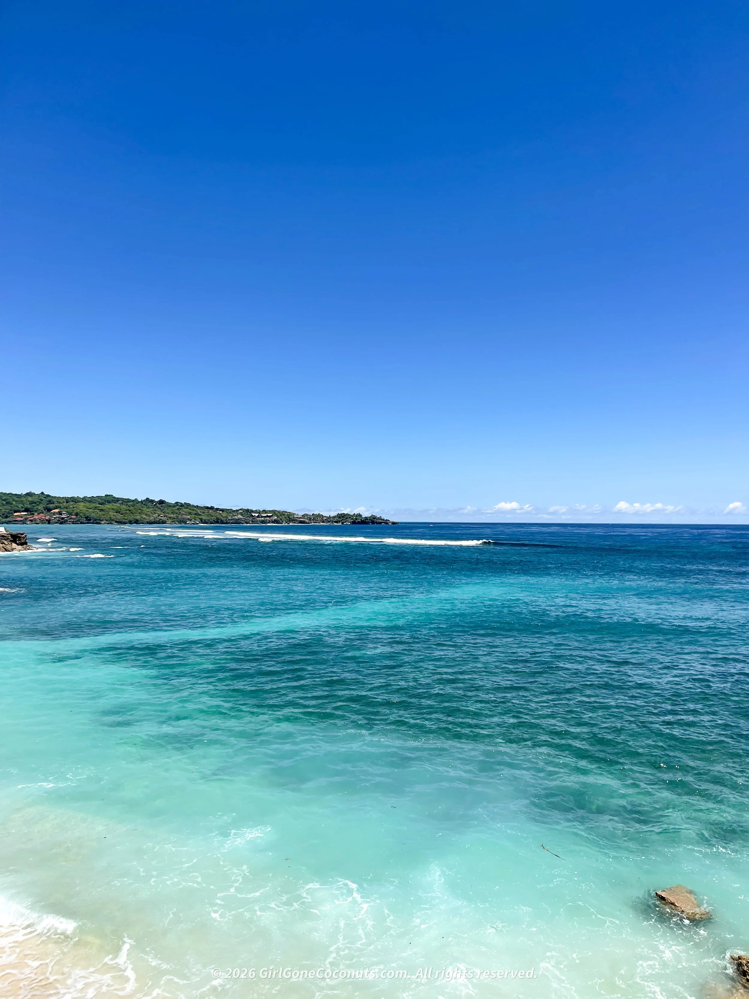 Dreamy views over Nusa Lembongan's turquoise coastline, lined with hotels, restaurants, and local boats.