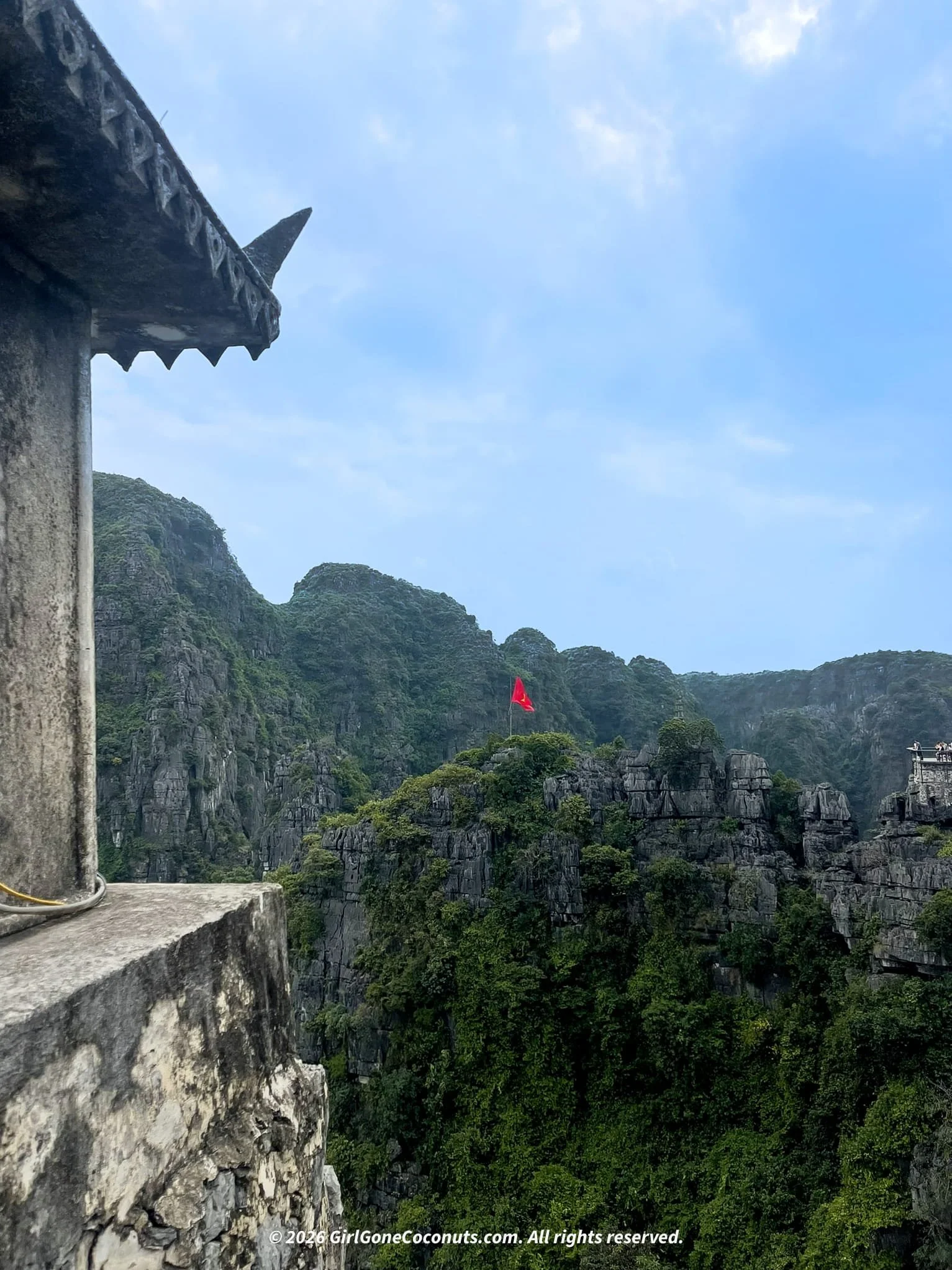 Panoramic view of limestone karsts and Vietnamese flag from the top of Hang Mua Viewpoint, Ninh Binh.