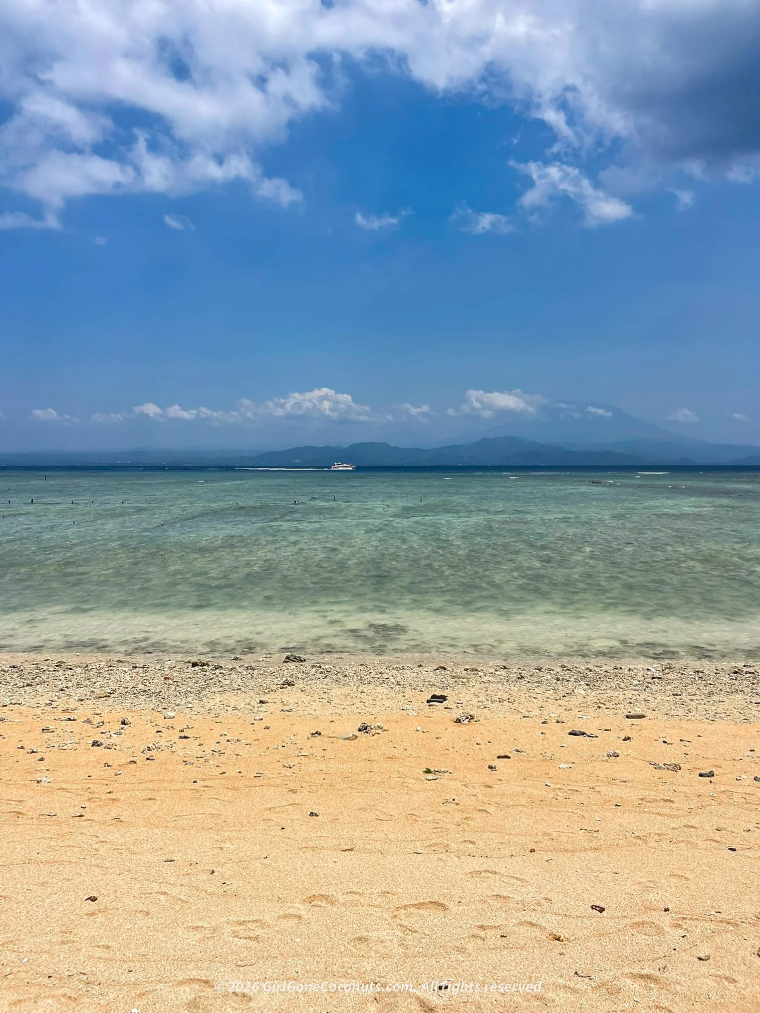 Mahagiri Beach in Nusa Lembongan, a wide stretch of sandy shoreline with calm water perfect for relaxing, lounging, and soaking up panoramic views of Mount Agung.