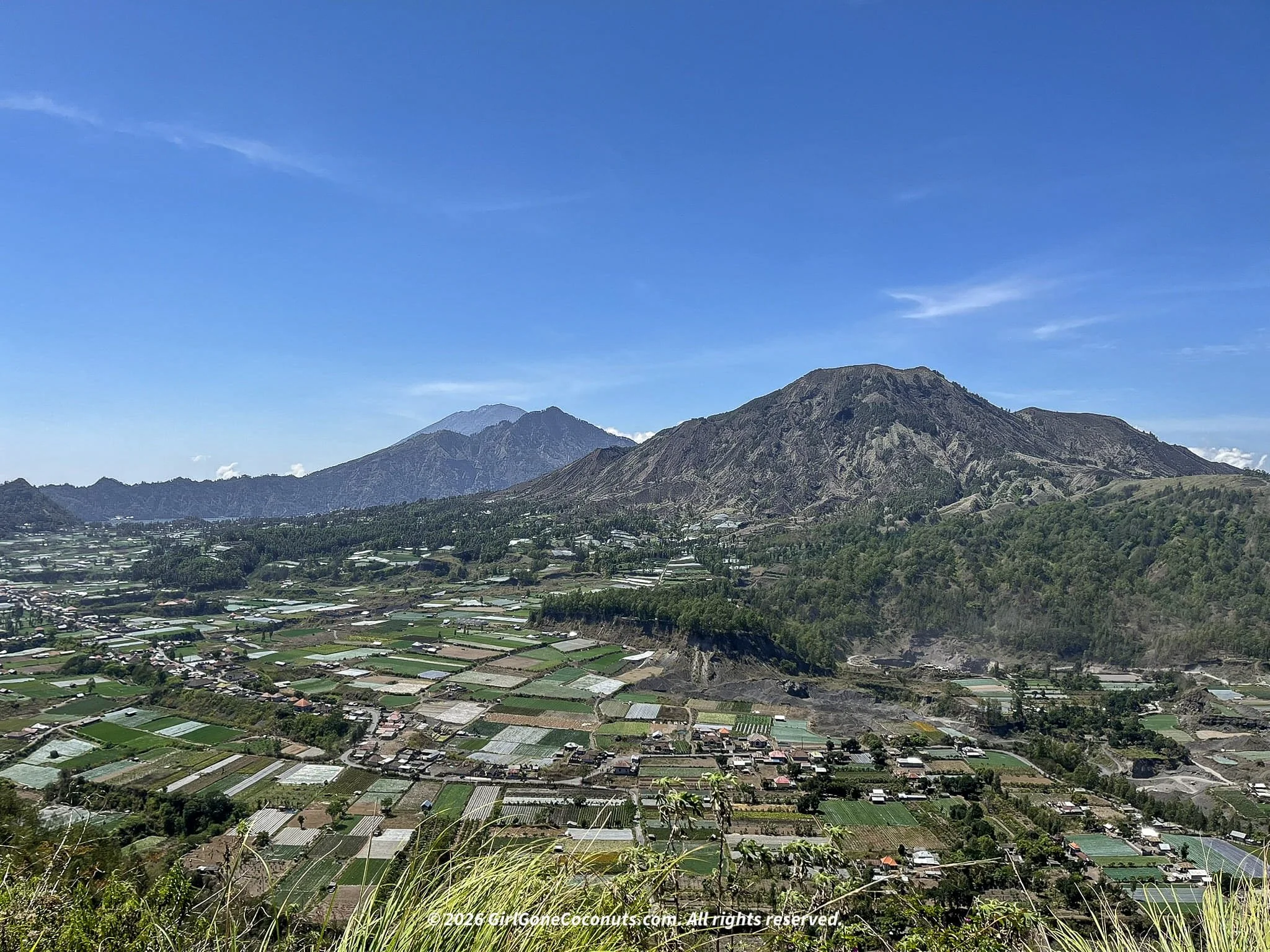 Aerial view of Mount Batur crater filled with villages and farmland in Kintamani, Bali