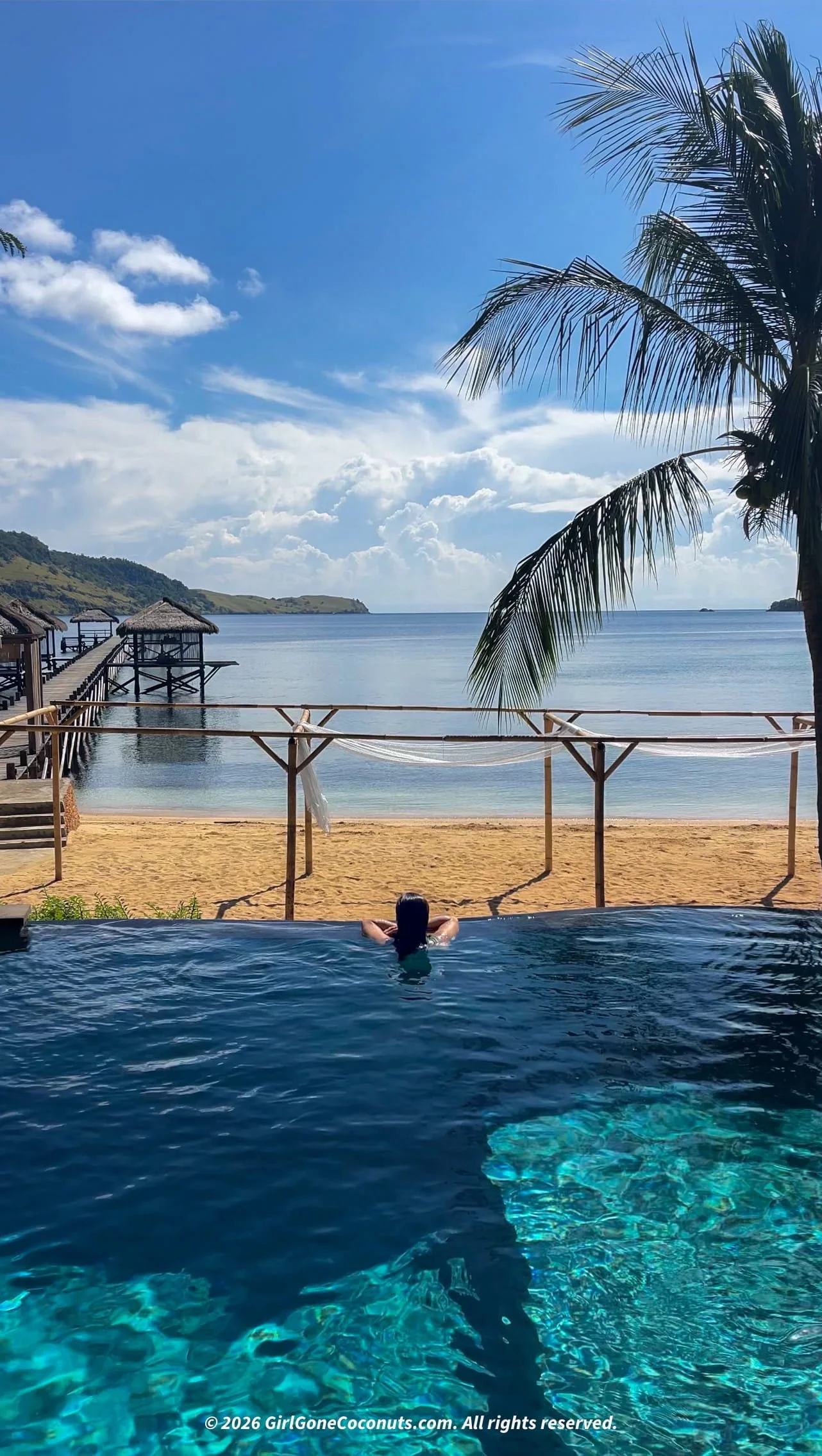 Traveler swimming in pool at The Seraya Resort in Komodo, Flores.