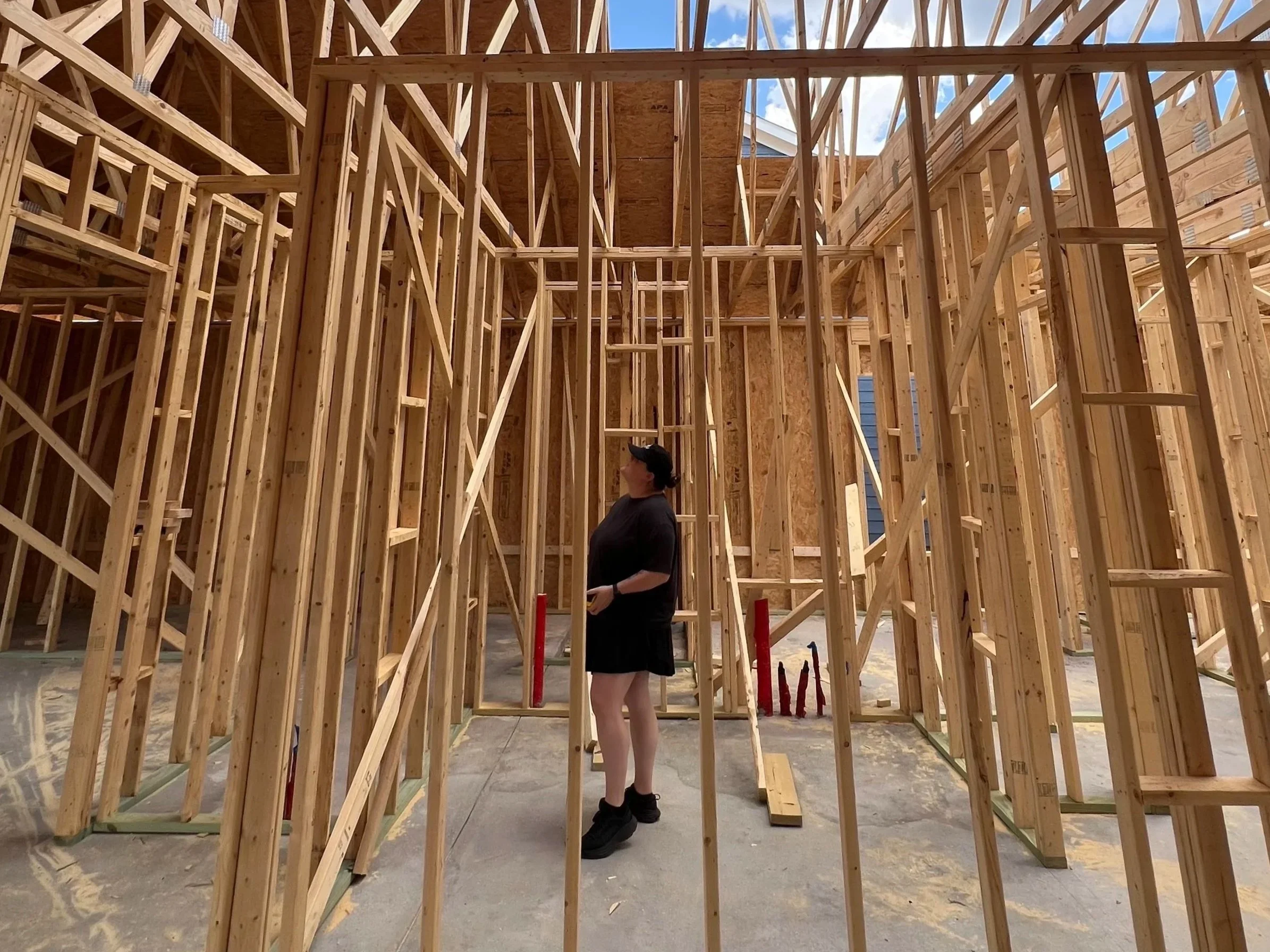 Interior designer standing inside a home during the framing phase of a renovation, illustrating how thoughtful home updates can improve layout, functionality, and long-term livability instead of moving.